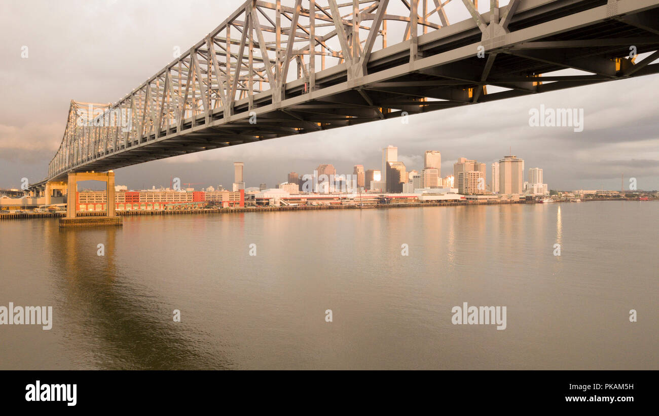 Il sole si rompe in nuvole temporalesche alla luce il New Orleans Skyline riflettendo nel fiume Mississippi Foto Stock