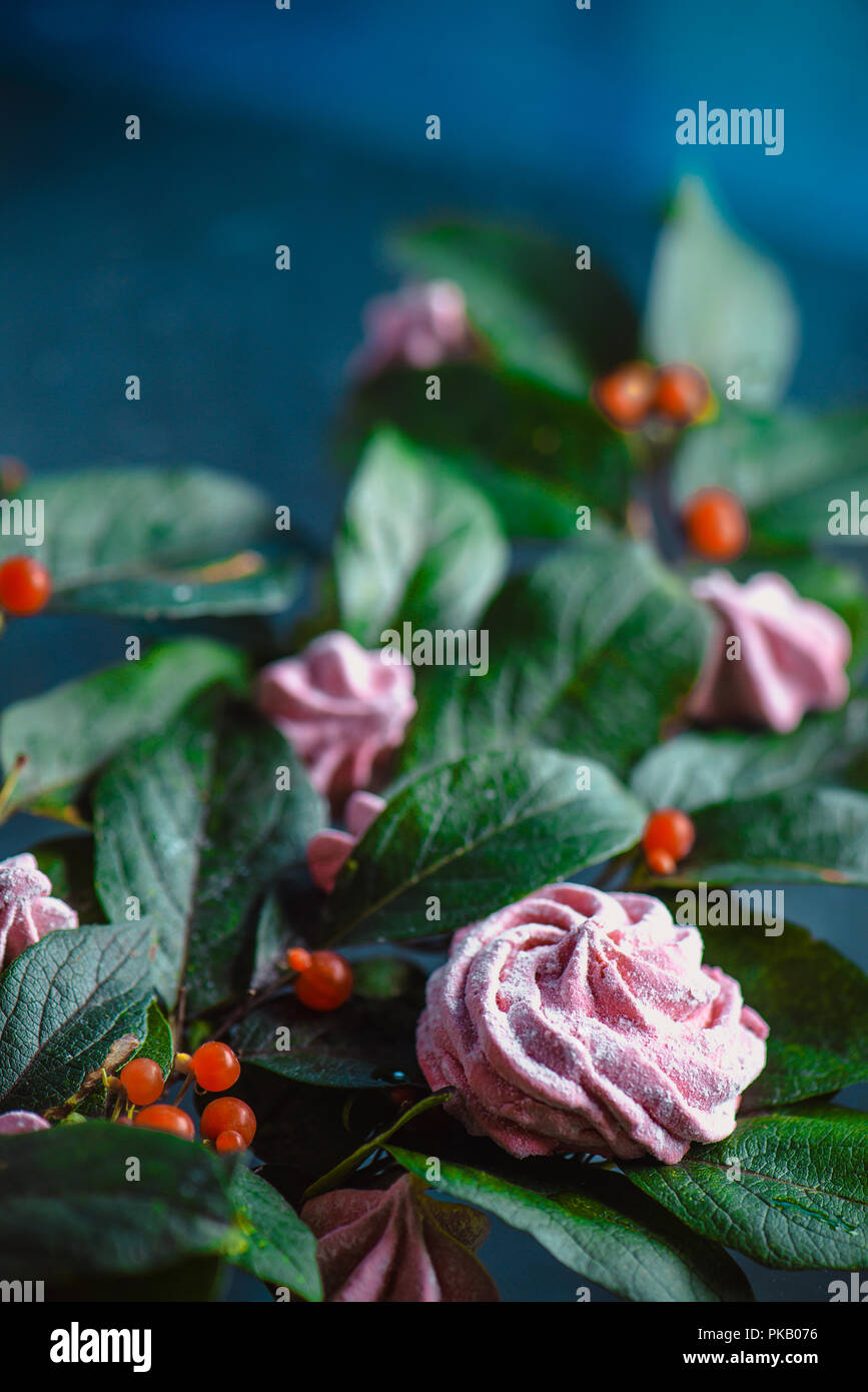 Meringhe o marshmallow in un mazzo di fiori su un di legno negli appunti. Composizione floreale in un moderno concetto di dessert Foto Stock