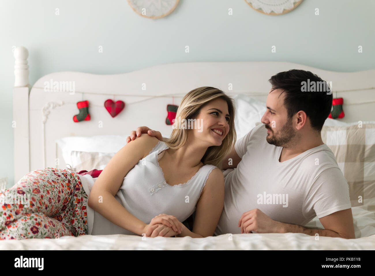 Giovane coppia attraente avente tempo di romantico nel letto Foto Stock
