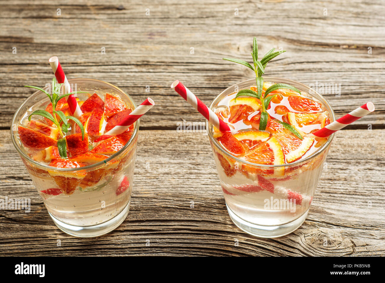 Acqua detox con arancia e rosmarino sul vecchio sfondo di legno come limonata ristoro. spazio per il testo Foto Stock