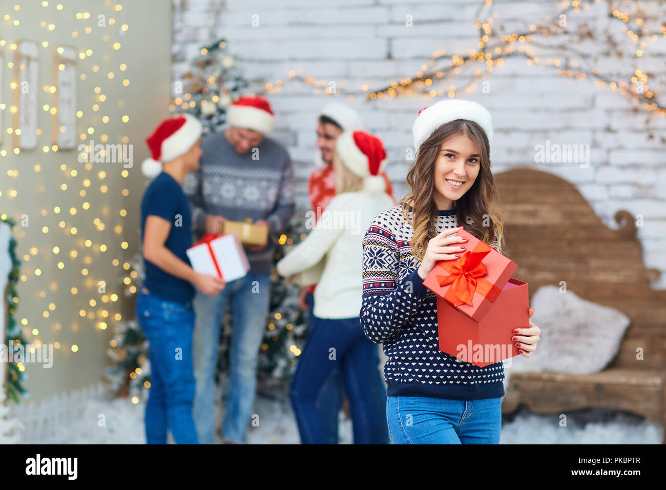 Un gruppo di amici con doni ad una festa di Natale Foto Stock