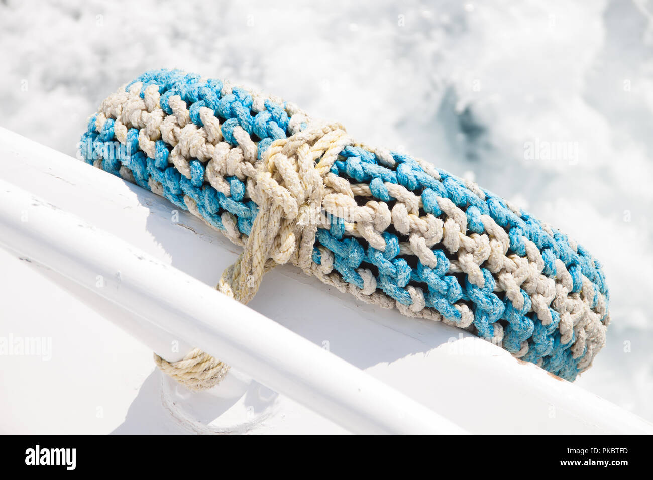 Pneumatico riciclato come parafango in barca con il mare in background Foto Stock