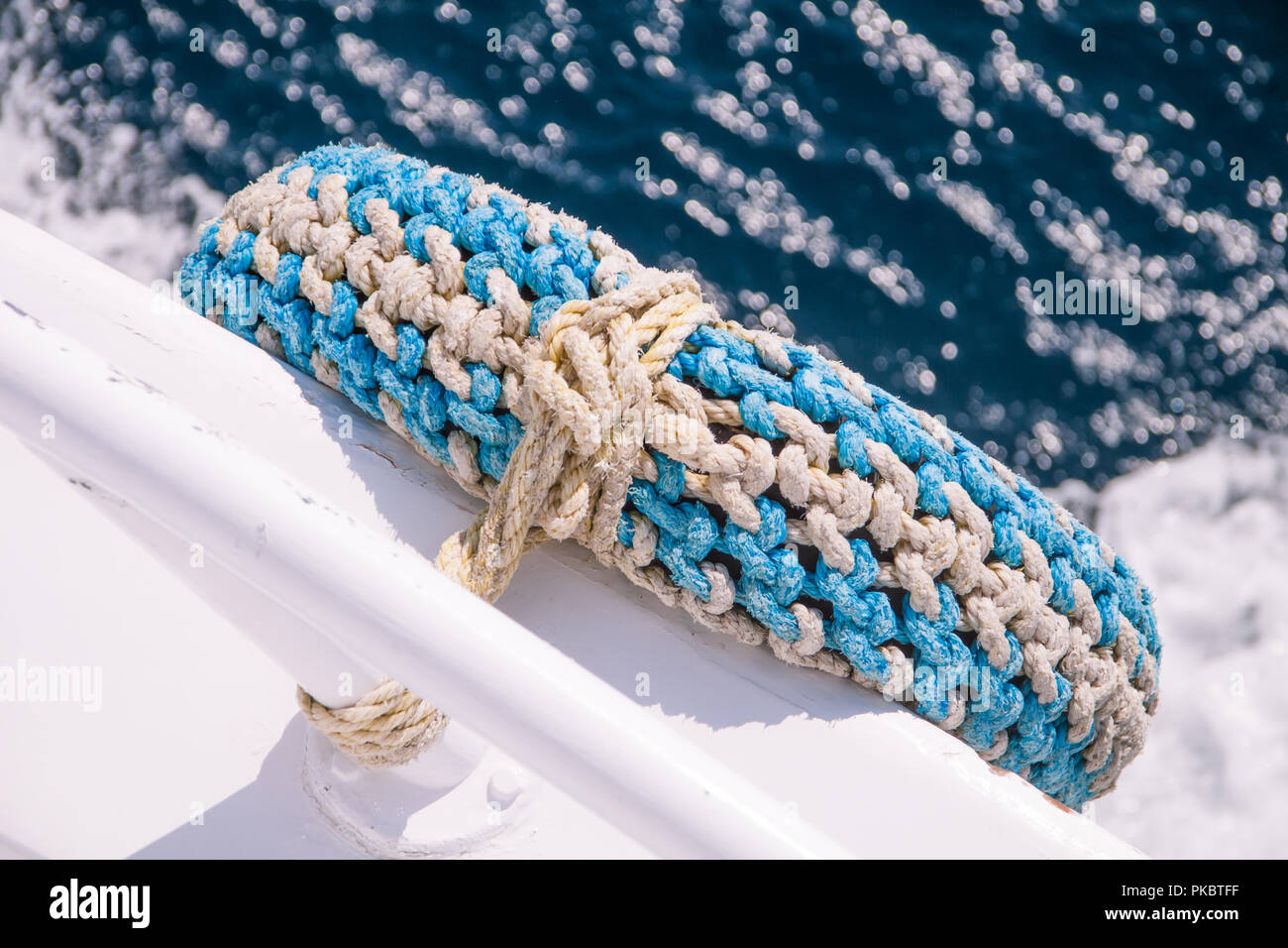 Pneumatico riciclato come parafango in barca con il mare in background Foto Stock
