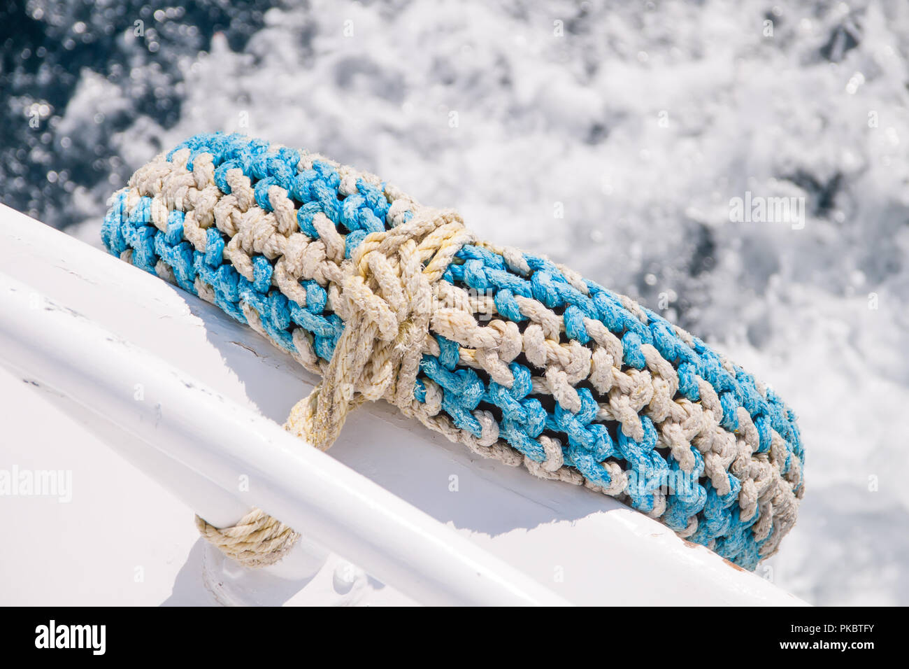 Pneumatico riciclato come parafango in barca con il mare in background Foto Stock