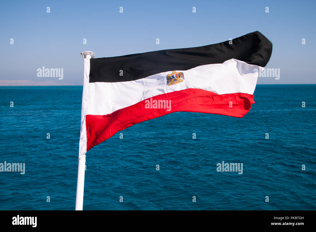 Bandiera egiziana in flottante il sole con mare rosso in background Foto Stock