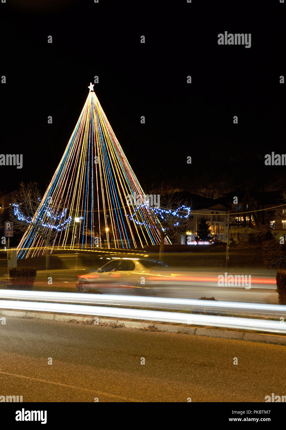 Albero di natale nel parco in Kastoria , Grecia e sentieri di luce di auto Foto Stock