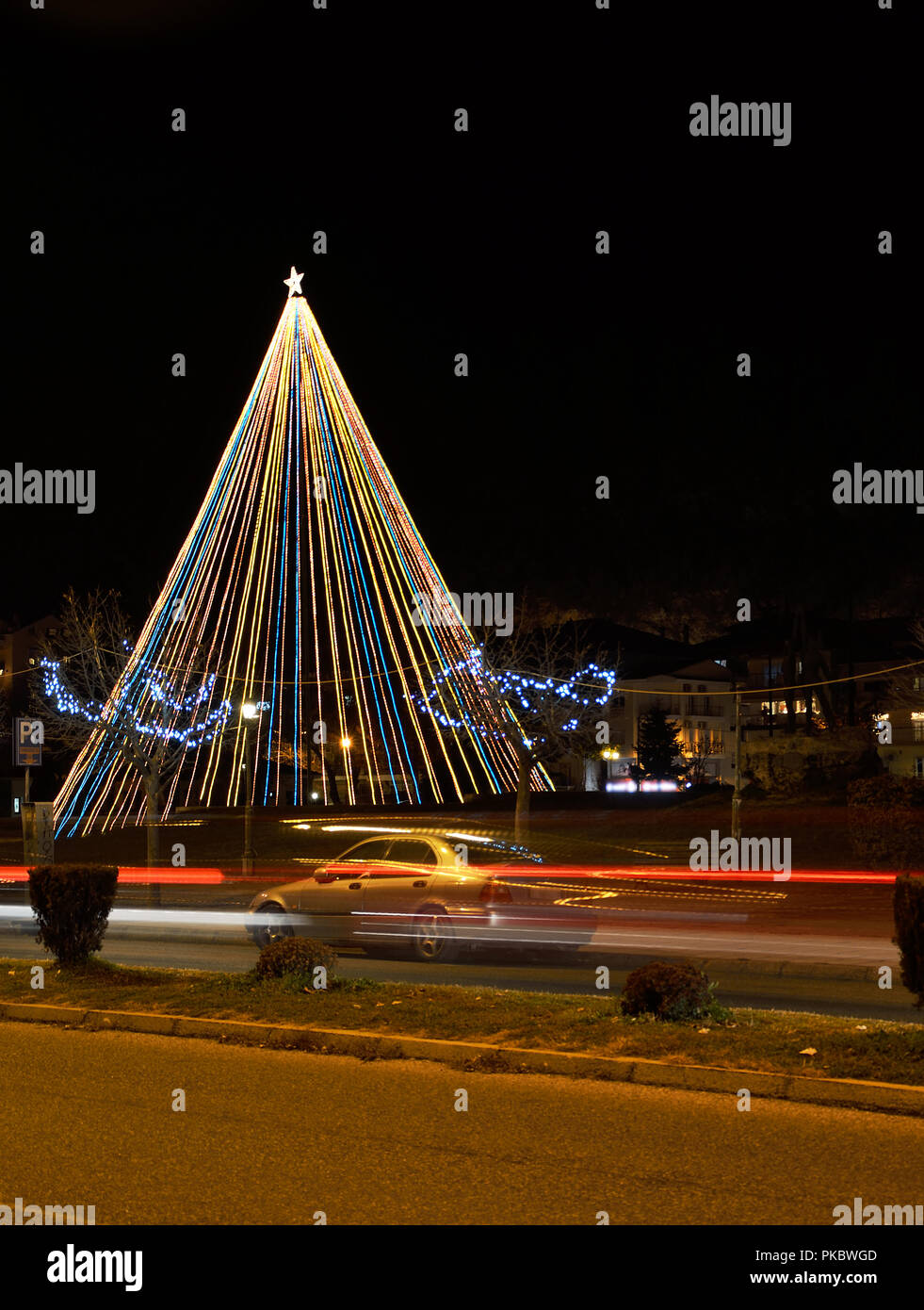 Albero di natale nel parco in Kastoria , Grecia e sentieri di luce di auto Foto Stock