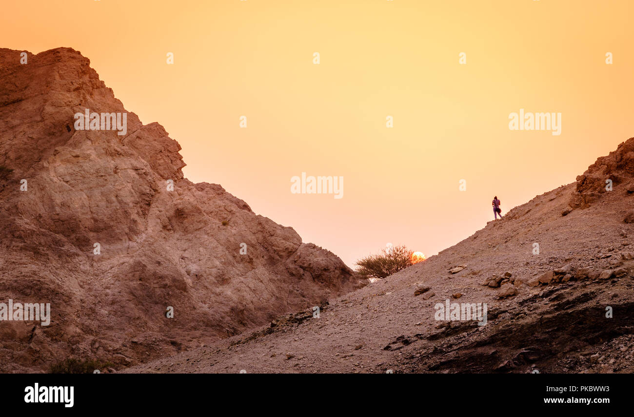 Escursionista è guardare il tramonto in montagne Hajar di Ras Al Khaimah negli Emirati arabi uniti Foto Stock