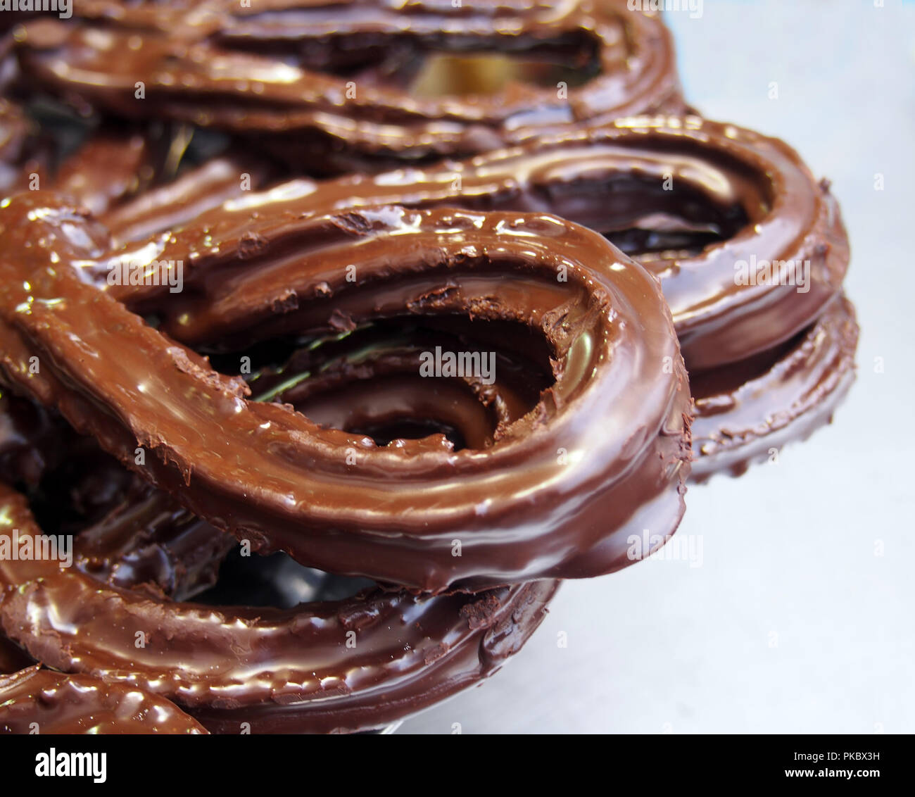 Spagnolo tradizionale fritto pasta-sfoglia churros in glassa di cioccolato Foto Stock