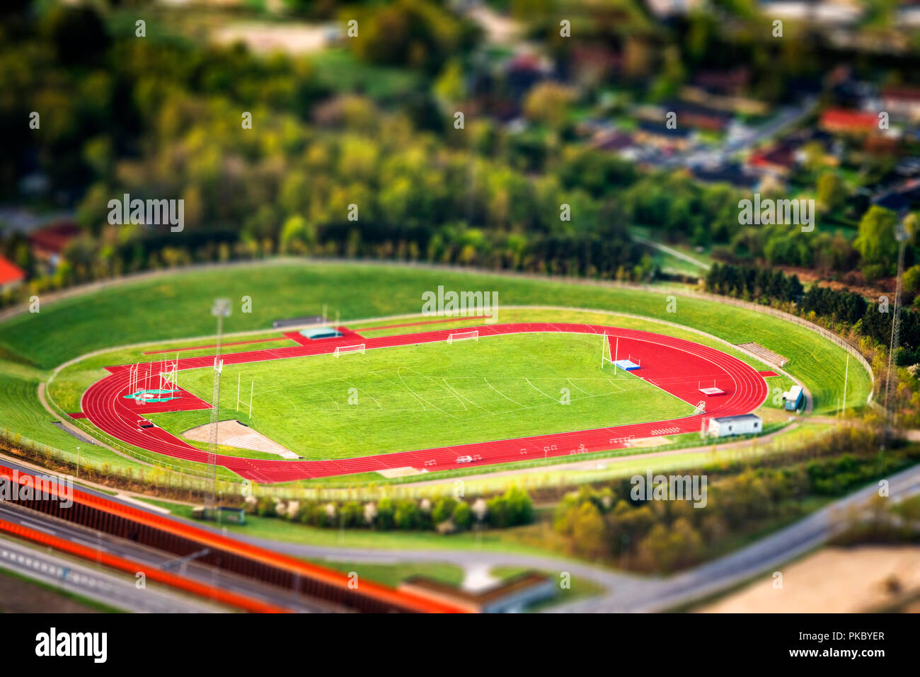 Lo stadio di atletica visto da sopra con gli oggetti in miniatura e un campo in erba nel centro Foto Stock