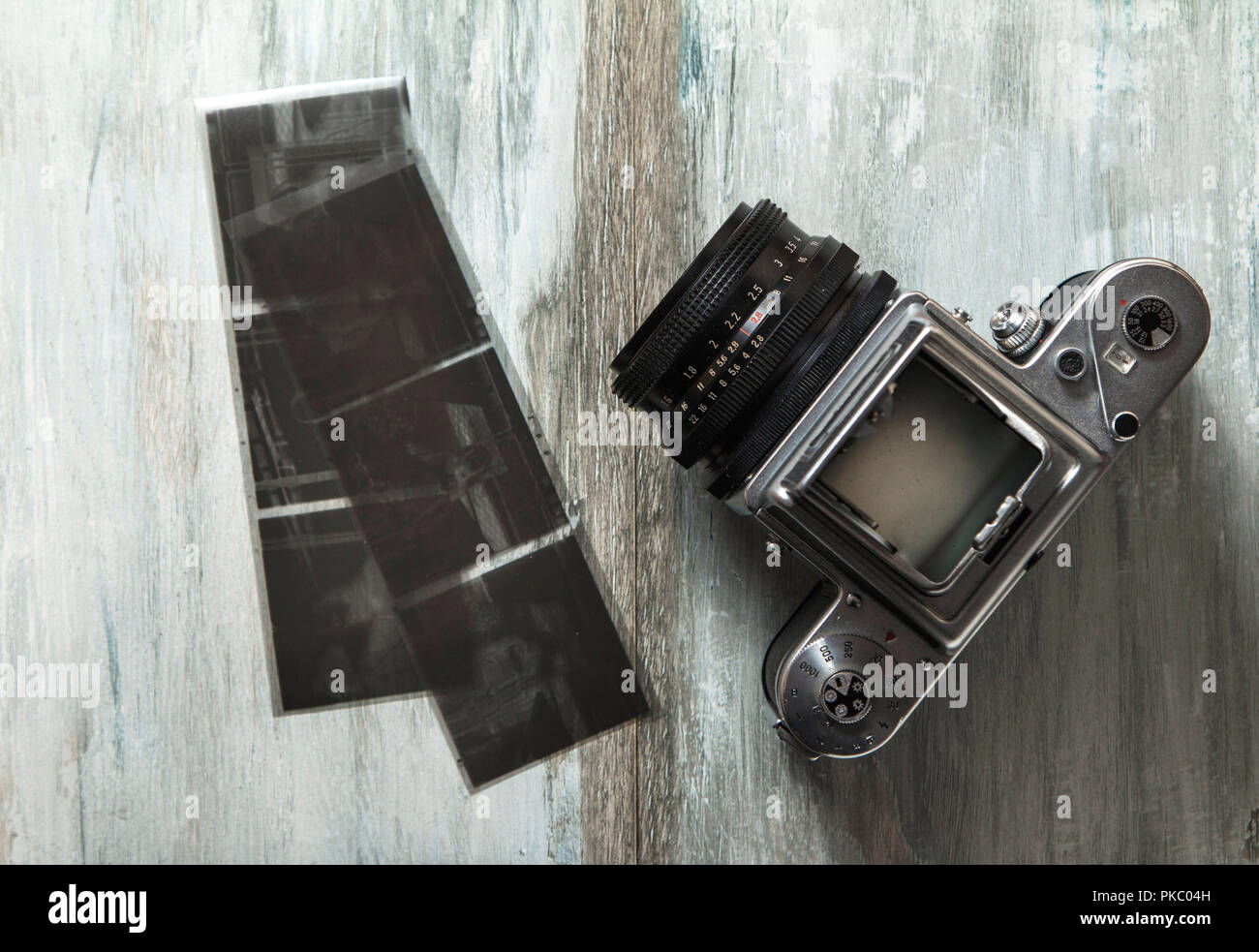 Vecchia fotocamera di medio formato e film sul tavolo di legno Foto Stock