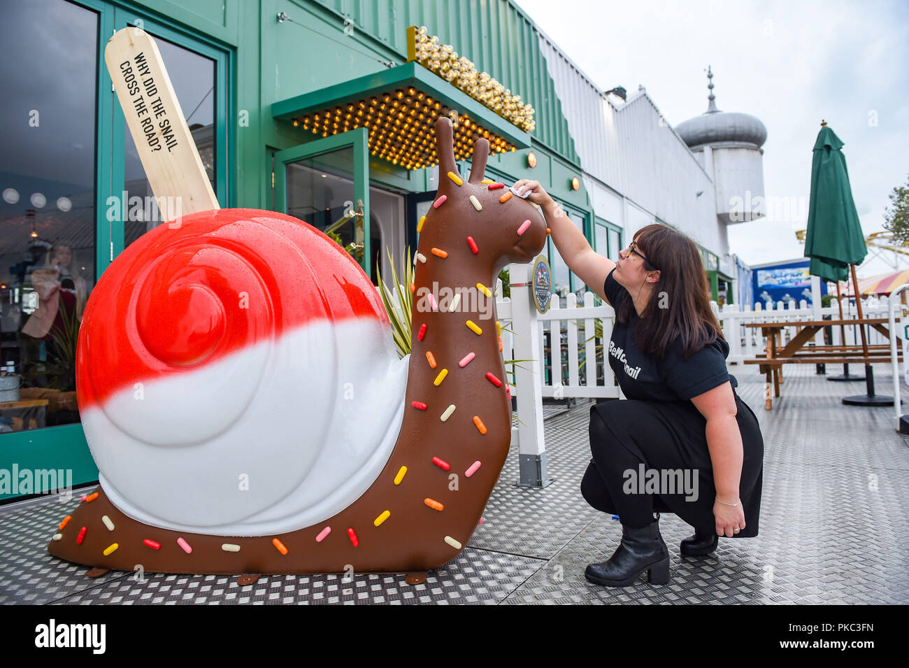 Brighton Regno Unito 12 Settembre 2018 - Kayla Fuller dà la lumaca sculture una cancellazione rapida al lancio dell'arte Snailspace Trail sul molo di Brighton oggi . Cinquanta decorate le lumache giganti e sessanta junior va a passo di lumaca sculture dipinte da artisti locali in collaborazione con Wild in arte saranno presenti intorno alla città di Brighton e Hove tra il XV Settembre fino al 18 novembre. Essi sono sponsorizzati da imprese locali e finirà per essere messo all'asta per raccogliere fondi per l'Ospizio Martlets Credito: Simon Dack/Alamy Live News Foto Stock