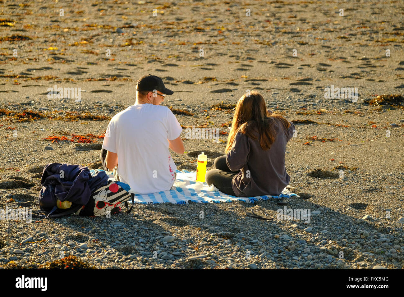 Aberystwyth Wales UK, mercoledì 12 settembre 2018 UK Meteo: un giovane sulla spiaggia in Aberystwyth, Galles , godendo di uno splendido sole e caldo a metà settembre sera Foto © Keith Morris / Alamy Live News Foto Stock