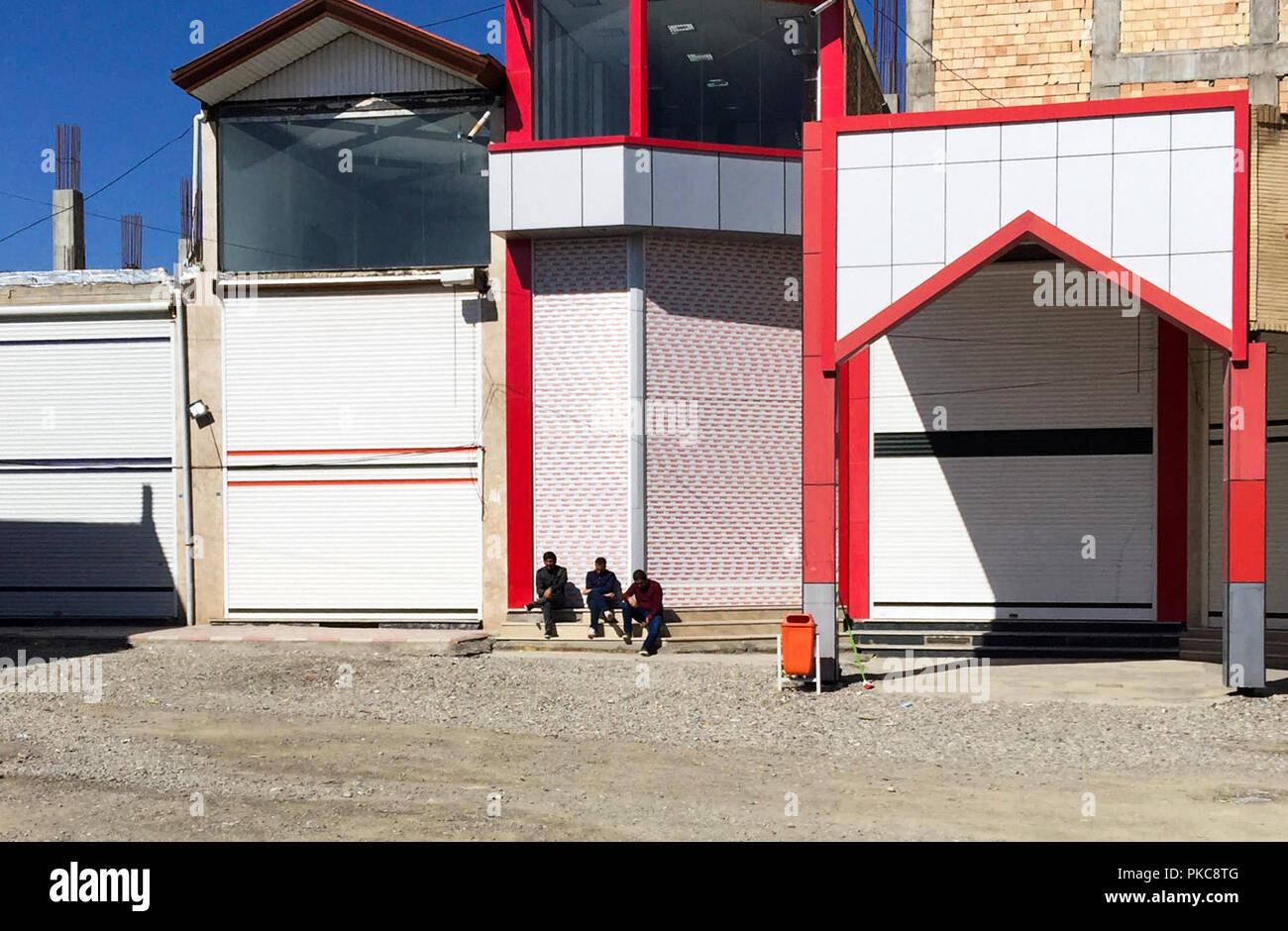 Urmia, Iran. Xvi Apr, 2018. Tre lavoratori iraniani sono seduto di fronte a negozi chiusi nel siero del mercato di confine vicino al confine turco-iraniana in Northwest Tira. Con la progressiva disidratazione del lago di Urmia e la mancanza di turisti, business sul confine Sero di mercato è anche un deterioramento. Credito: Farshid-Motahari Bina/dpa/Alamy Live News Foto Stock