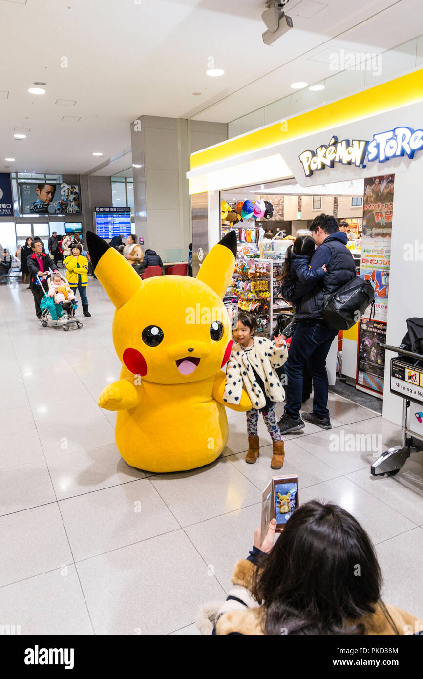 Giappone, Osaka. L'Aeroporto Internazionale di Kansai. KIX, Interior terminal uno, partenze nazionali. Bambino, ragazza, posa con carattere di Pokemon per foto Foto Stock