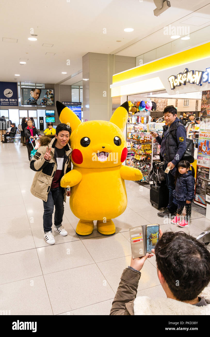 Giappone, Osaka. L'Aeroporto Internazionale di Kansai. KIX, Interior terminal uno, partenze nazionali. Bambino, ragazzo, posa con carattere di Pokemon per foto Foto Stock