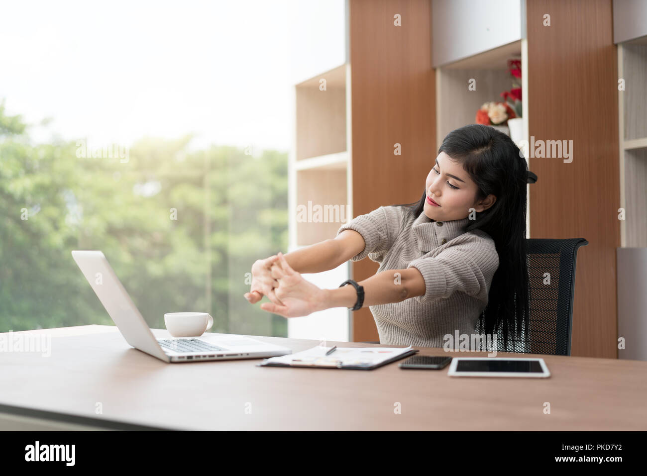 Giovani asiatici imprenditrice è rilassante in ufficio. Asian imprenditrice si allunga il suo corpo. Foto Stock