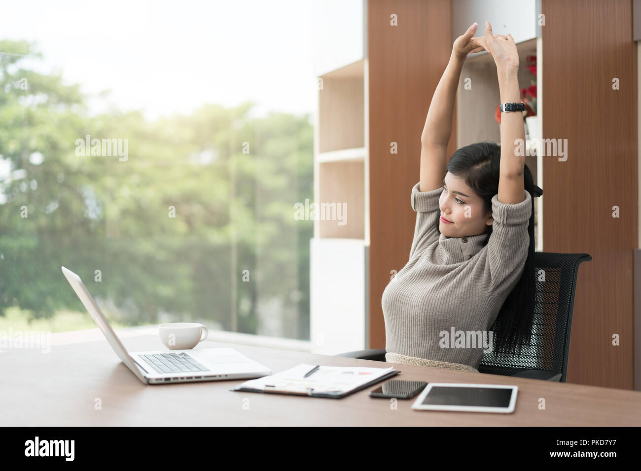 Giovani asiatici imprenditrice è rilassante in ufficio. Asian imprenditrice si allunga il suo corpo. Foto Stock