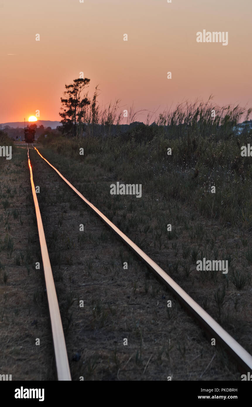 Treno turistico Barril in spiaggia al tramonto Foto Stock