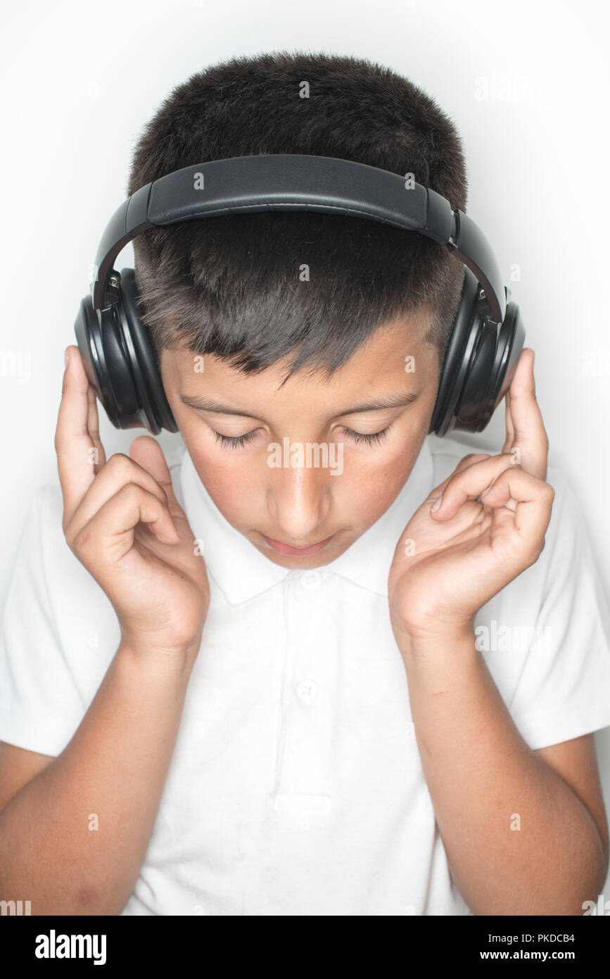 Ragazzo,10 anni ascolta musica sulle cuffie Foto Stock