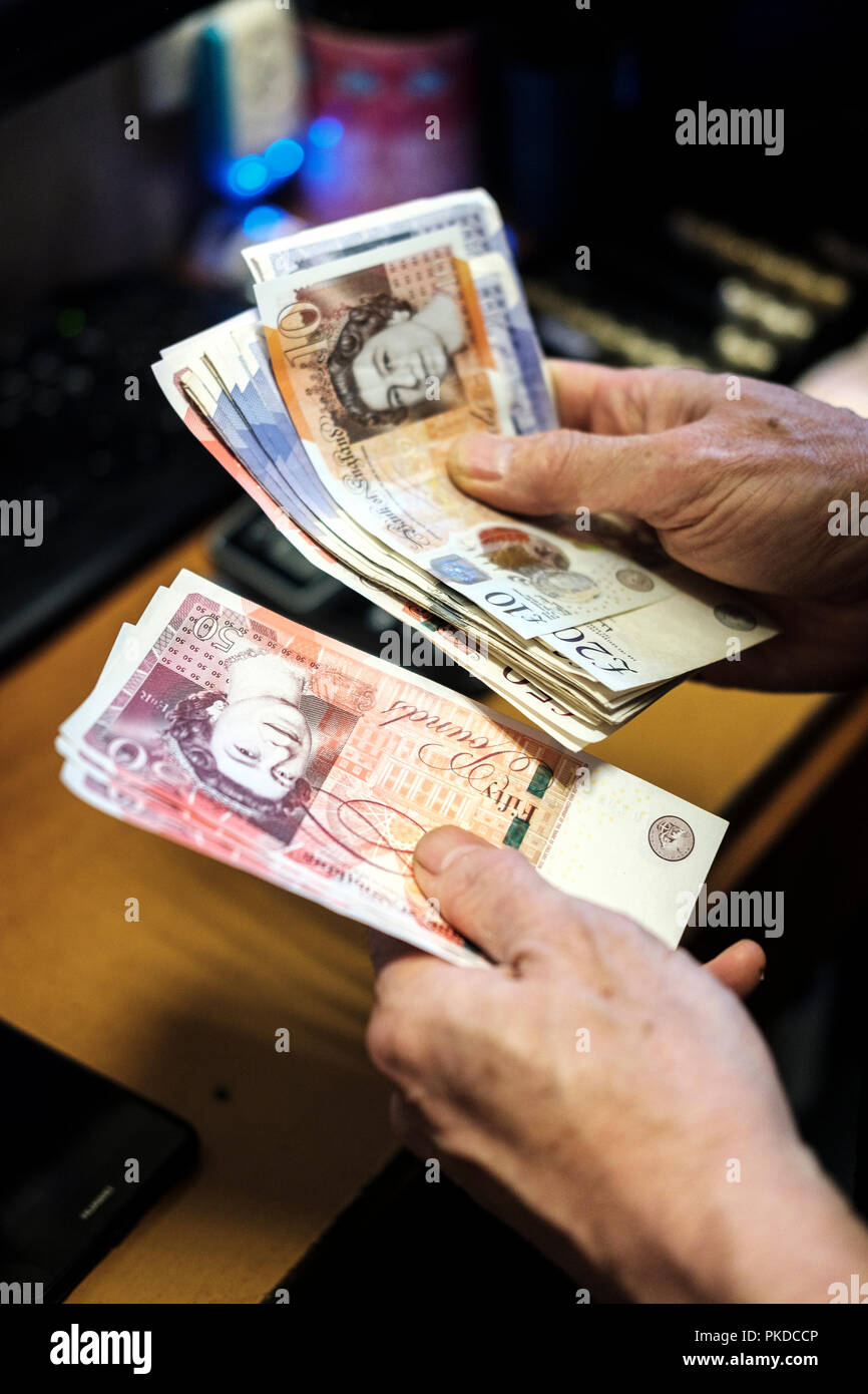 Il conteggio di cash-Pound sterling Banconote Foto Stock