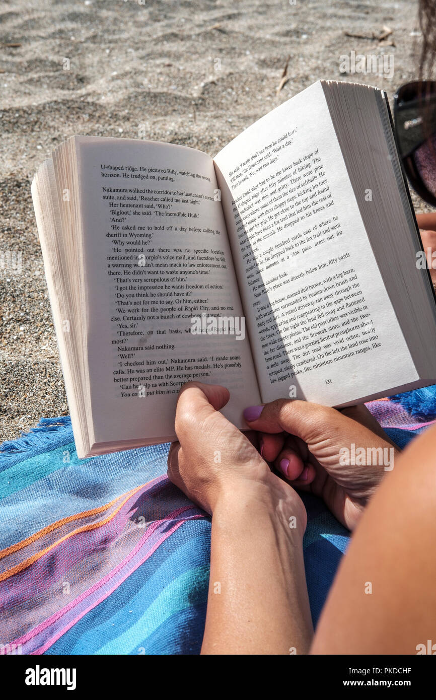La lettura di un libro sulla spiaggia-close-up Foto Stock