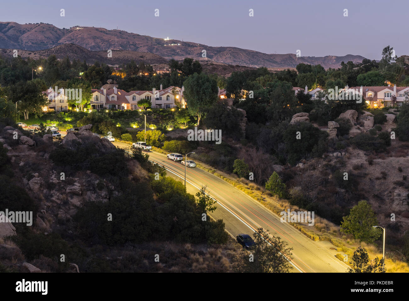 Vista del tramonto di case di collina incastonato nella roccia sopra la valle di San Fernando a Los Angeles in California. Foto Stock