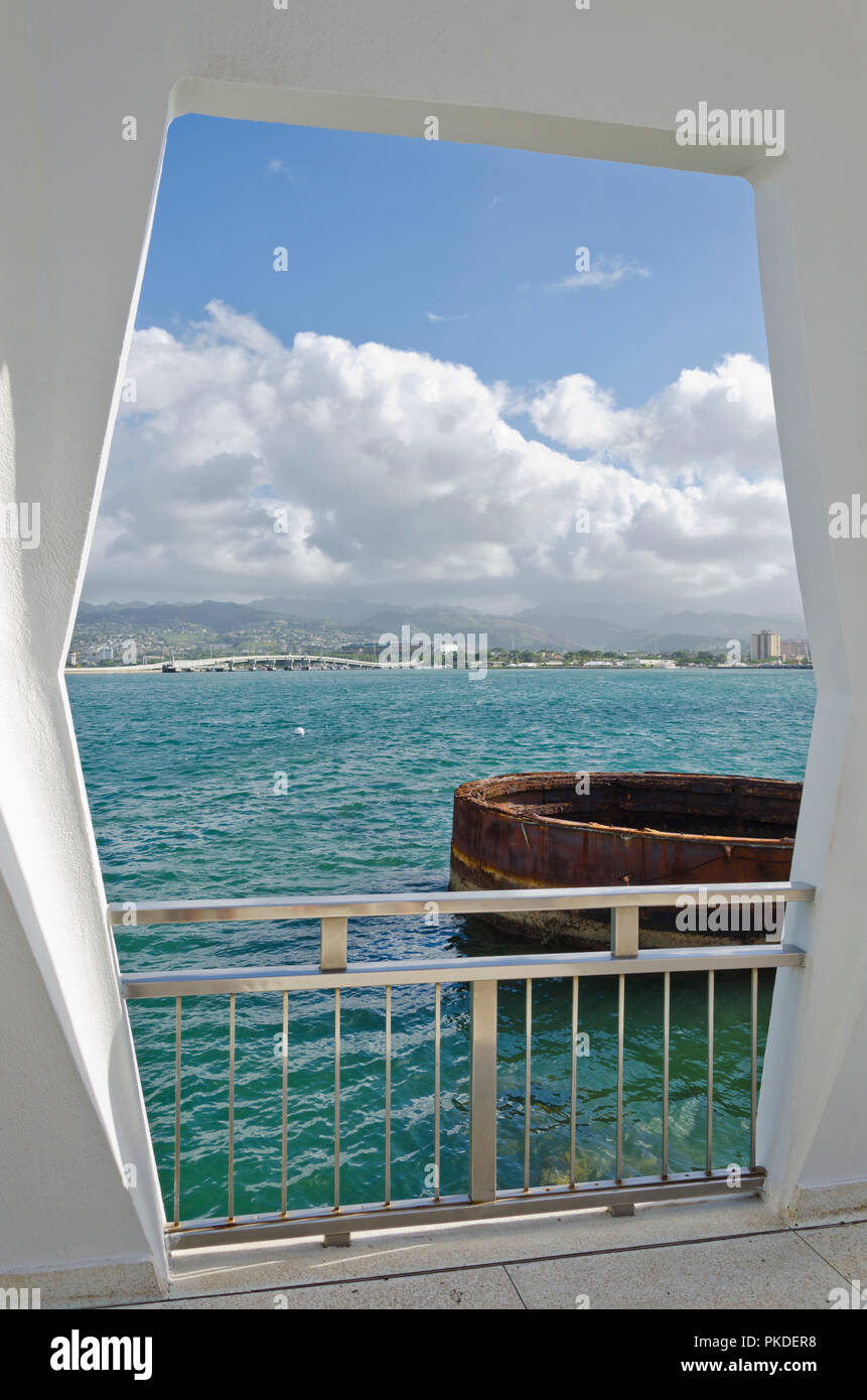USS Arizona Memorial di Pearl Harbor, Hawaii, guardando fuori dal monumento a parte della USS Arizona rising dall'acqua e Honolulu in background. Foto Stock