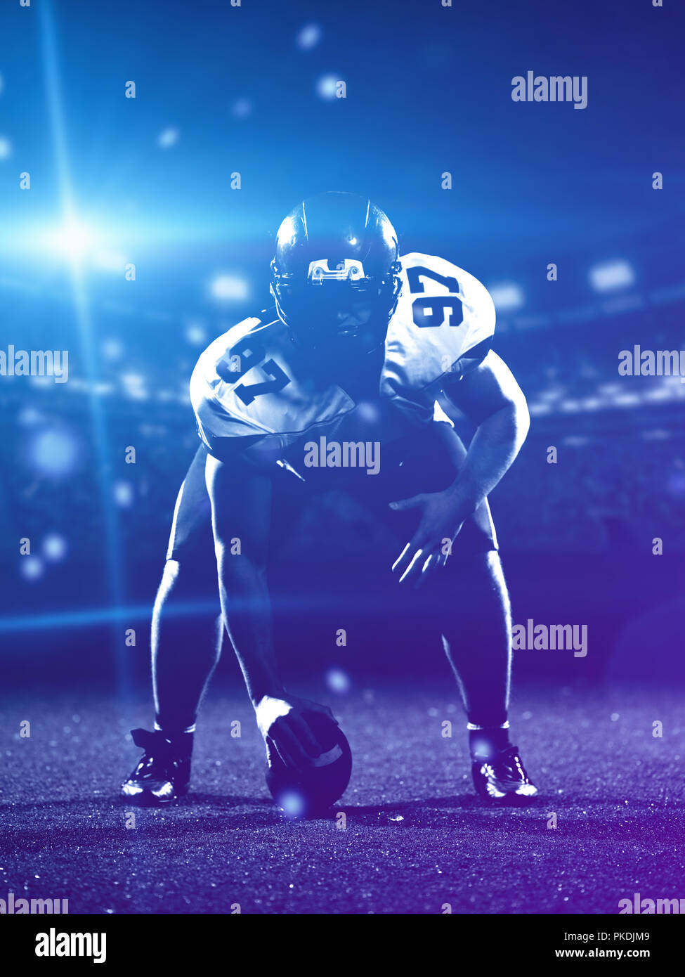 Giocatore di football americano a partire del gioco del calcio americano sul campo di calcio di notte Foto Stock