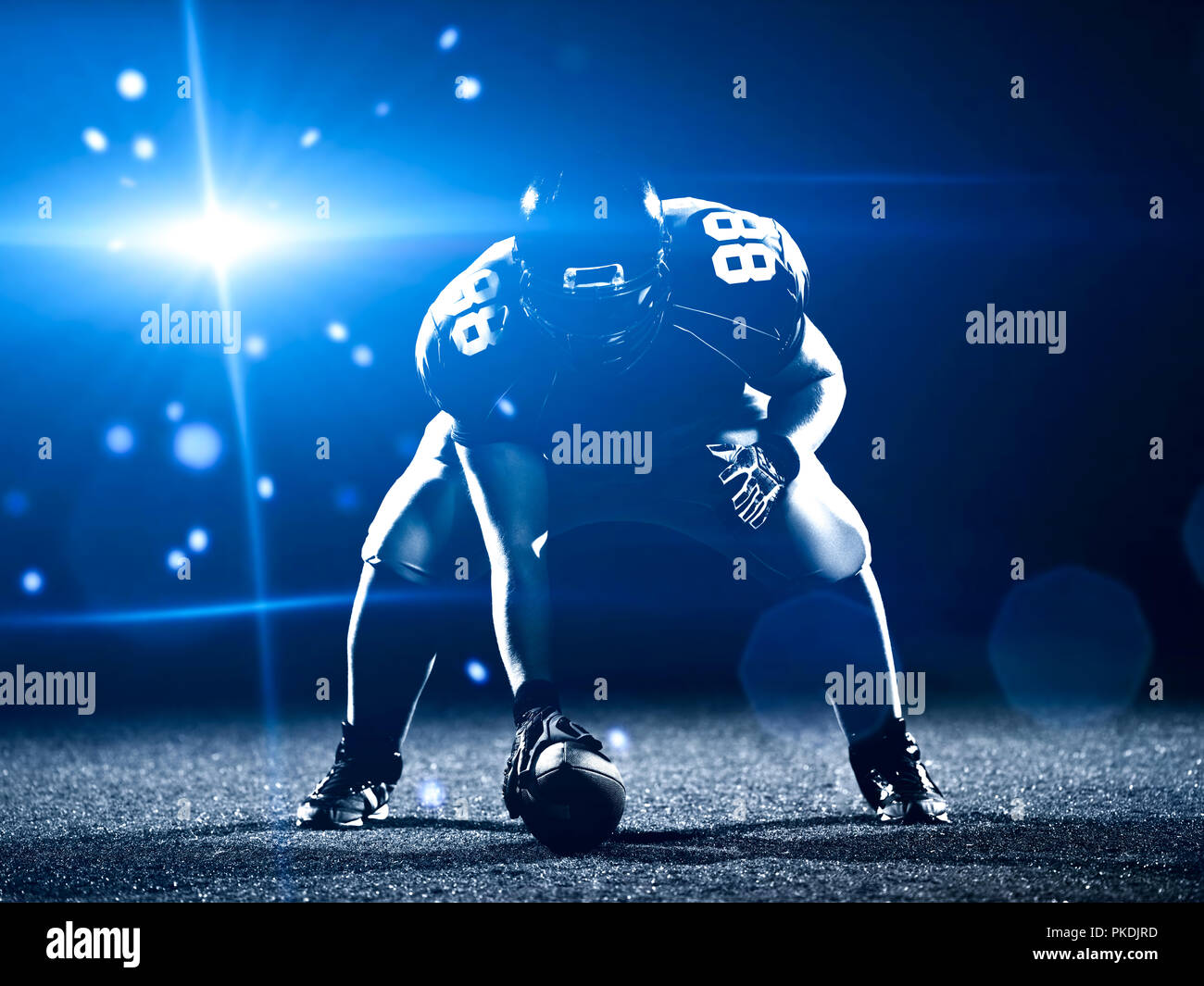 Giocatore di football americano a partire del gioco del calcio americano sul campo di calcio di notte Foto Stock