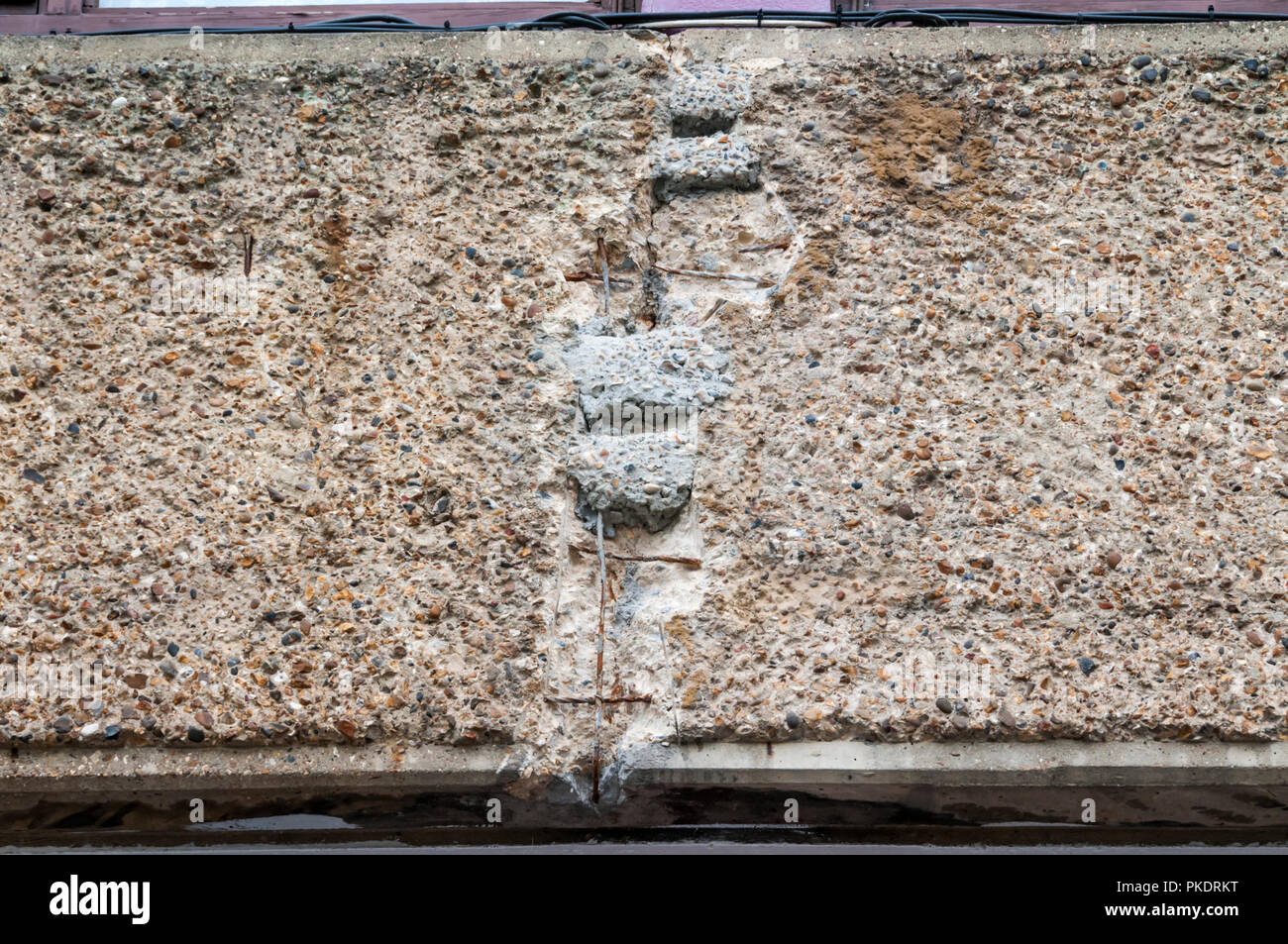 Spalled concrete sulle travi di cemento a Golden Lane station wagon. Mostra copertura inadeguata di rinforzo. Prove di riparazione precedente. Foto Stock