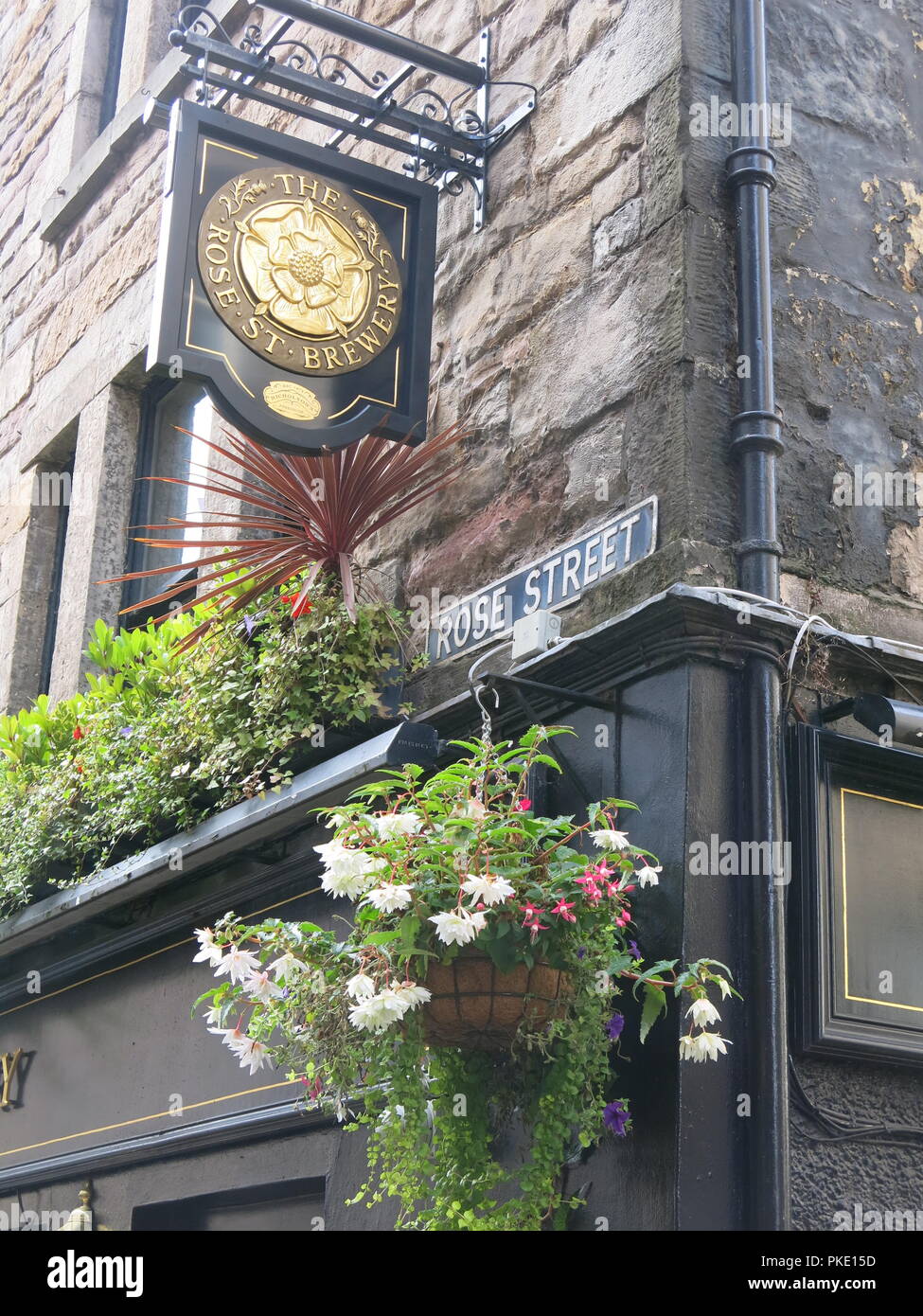 Cloe-up della targhetta "ROSE STREET' sull'angolo del pub Nicholson edificio, con la pubblicità di orientamento "Rosa birreria St'; Edimburgo. Foto Stock