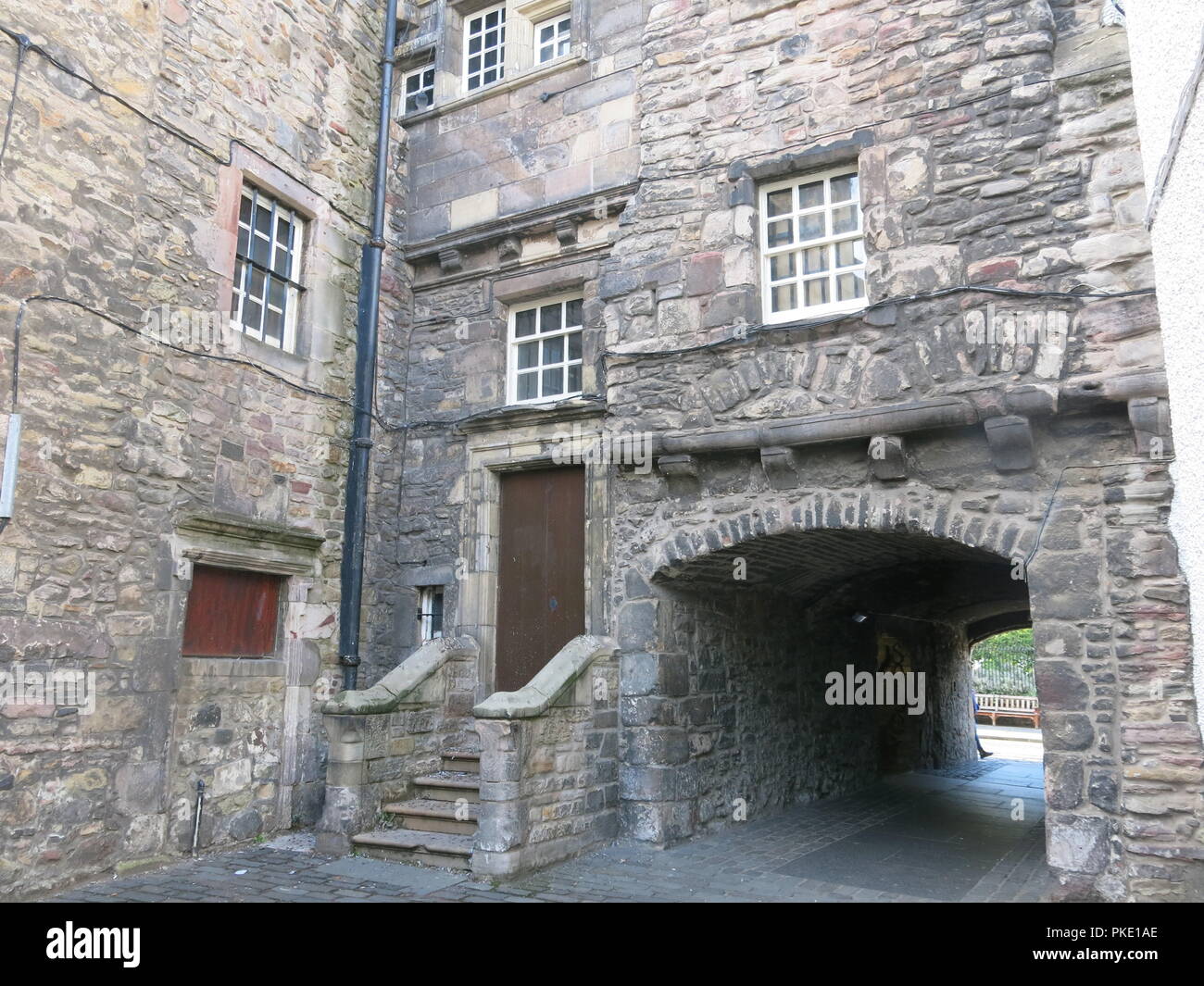 Edifici in pietra e sottopassaggio ad arco in un piccolo cortile off High Street; ad esplorare i vicoli di Edinburgh Old Town Foto Stock