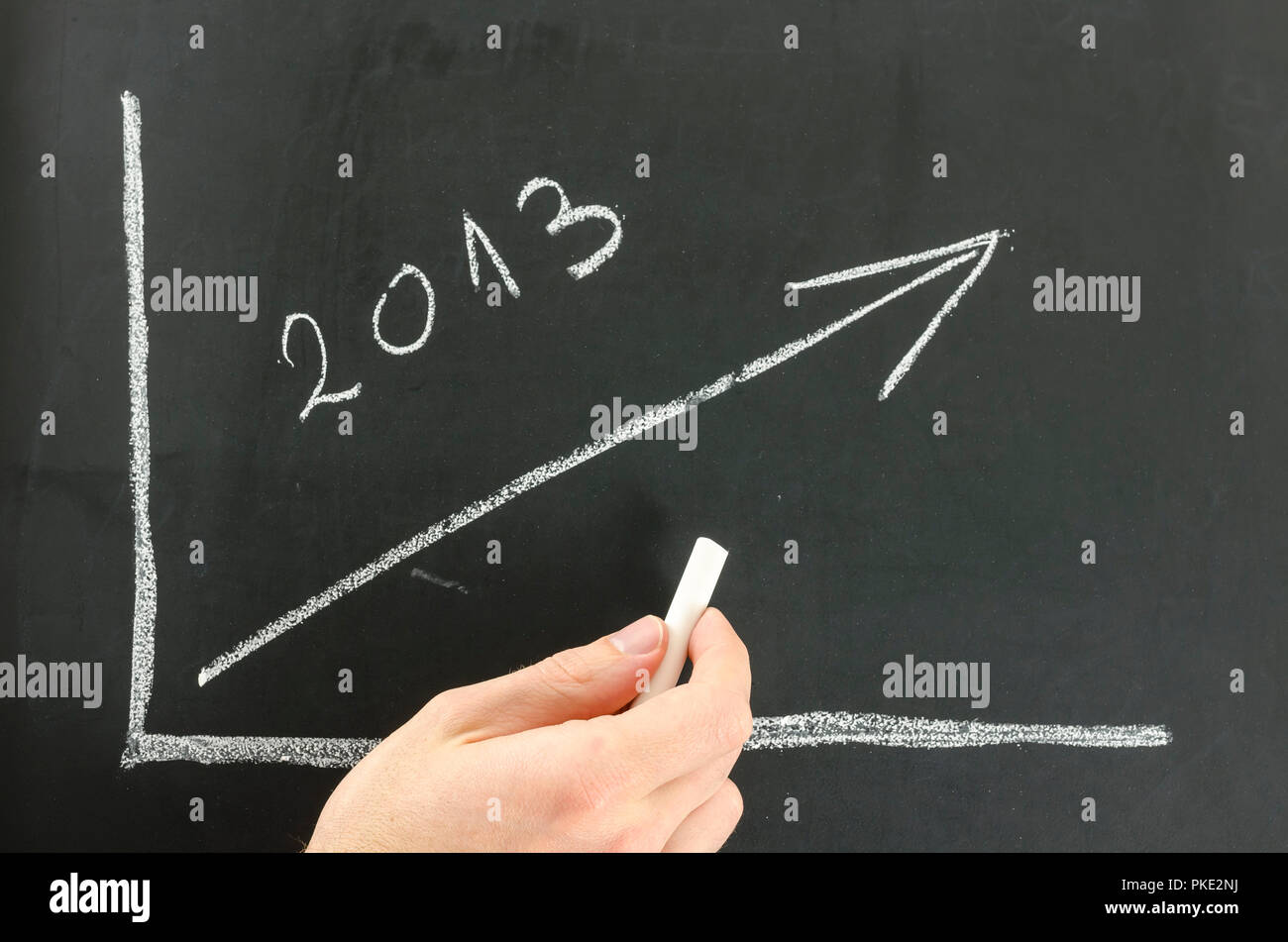 Imprenditore che mostra il grafico in crescita per l'anno 2013 su una scheda di colore nero. Foto Stock