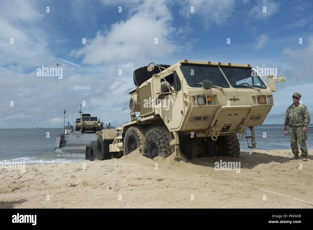 VIRGINIA BEACH, Va. (25 luglio 2018) UN U.S. Esercito Oshkosh pesanti Mobilità Estesa Tactical carrello aziona su Utah beach dopo lo sbarco di una marina migliorato sistema di alleggio (INLS) Causeway traghetto mentre partecipa in esercizio Trident Sun 18 a bordo comune Base Expeditionary Little Creek - Fort Story. Trident Sun 18 è un preposizionamento marittima forza (MPF) operazione destinata a fornire una formazione alla componente di riserva personale per quanto riguarda il flusso in offload di veicoli e attrezzature militari. Foto Stock