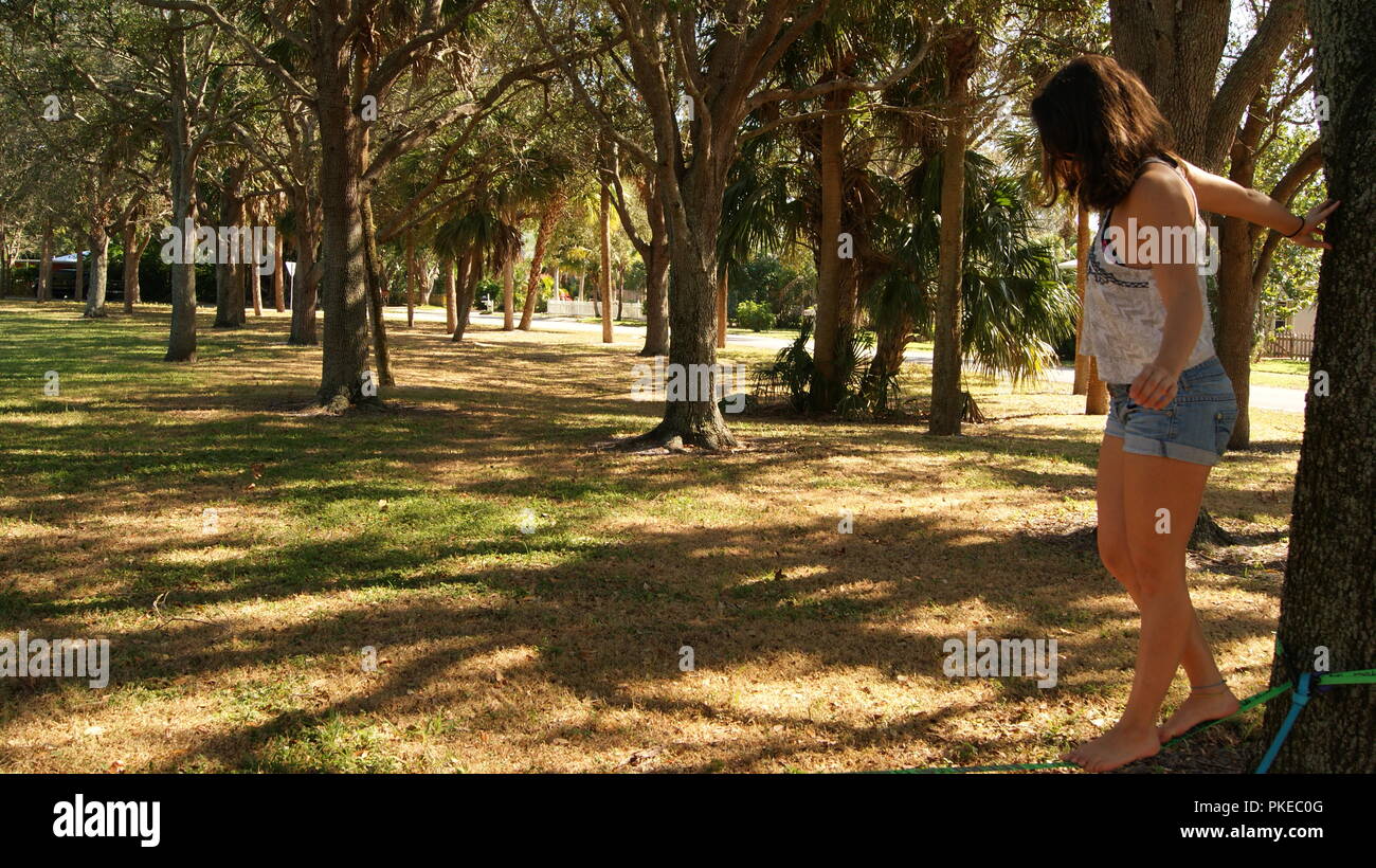 Giovane donna facendo pratica slackline sul parco pubblico in Florida, Jupiter, Florida. Stati Uniti d'America - 17 giugno 2017. Foto Stock