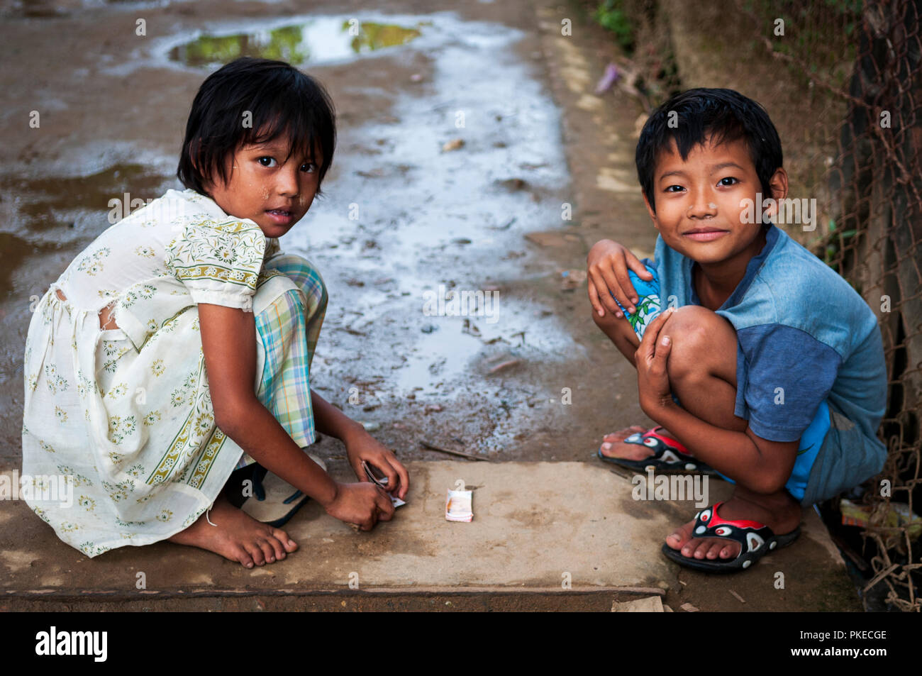 Due giovani bambini giocando a carte in uno dei vicoli di Yangon; Yangon, Myanmar Foto Stock