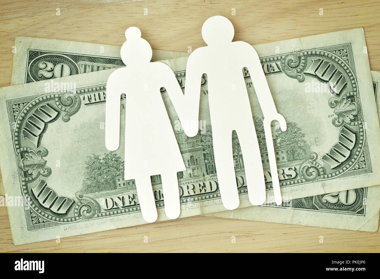 Carta coppia di anziani cut-out sul dollaro banconote - Concetto di pensione Foto Stock
