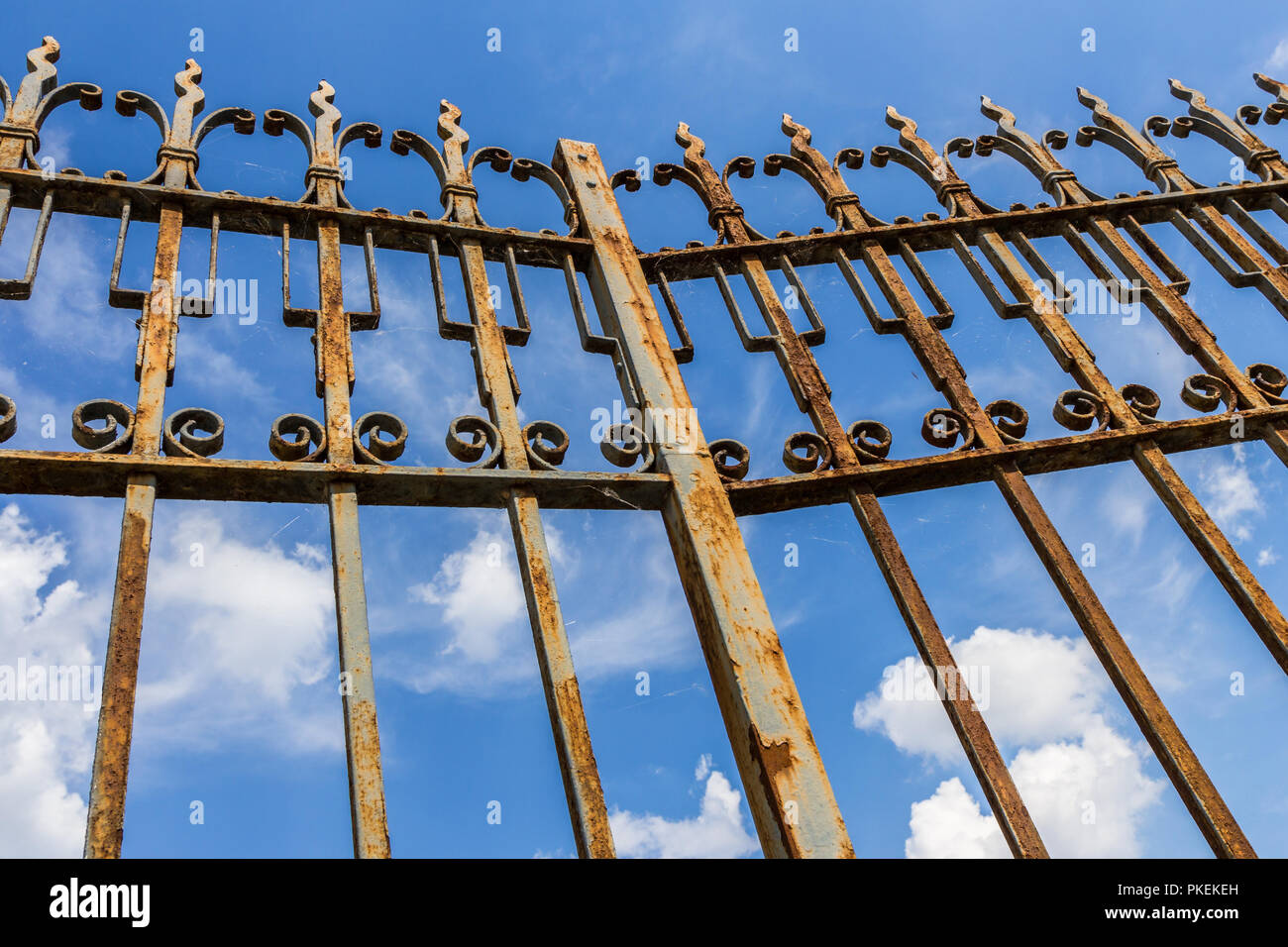 Antico cancello arrugginito in primo piano sul cielo azzurro sfondo con nuvole. Ideale per lavori di ristrutturazione i concetti. Foto Stock