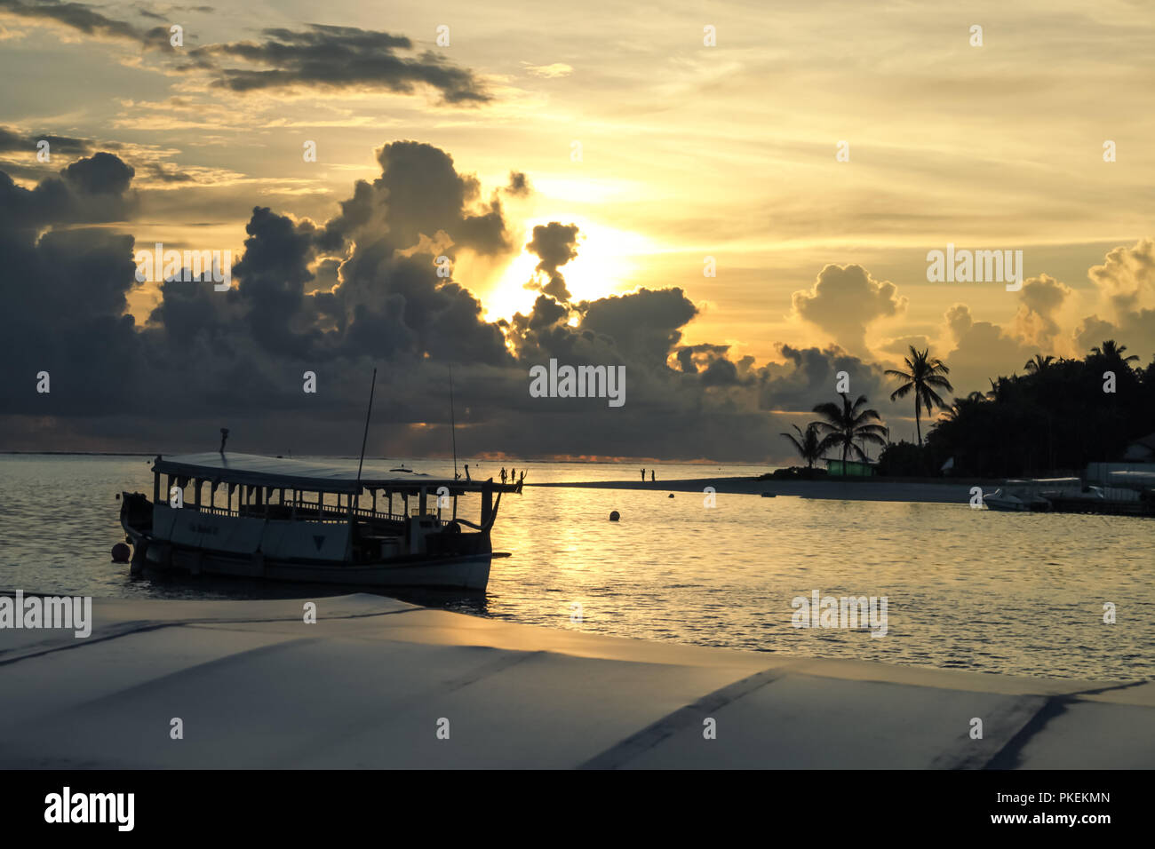 Barche maldiviano ("Dhonis') e resort isola nel tramonto tropicale Foto Stock
