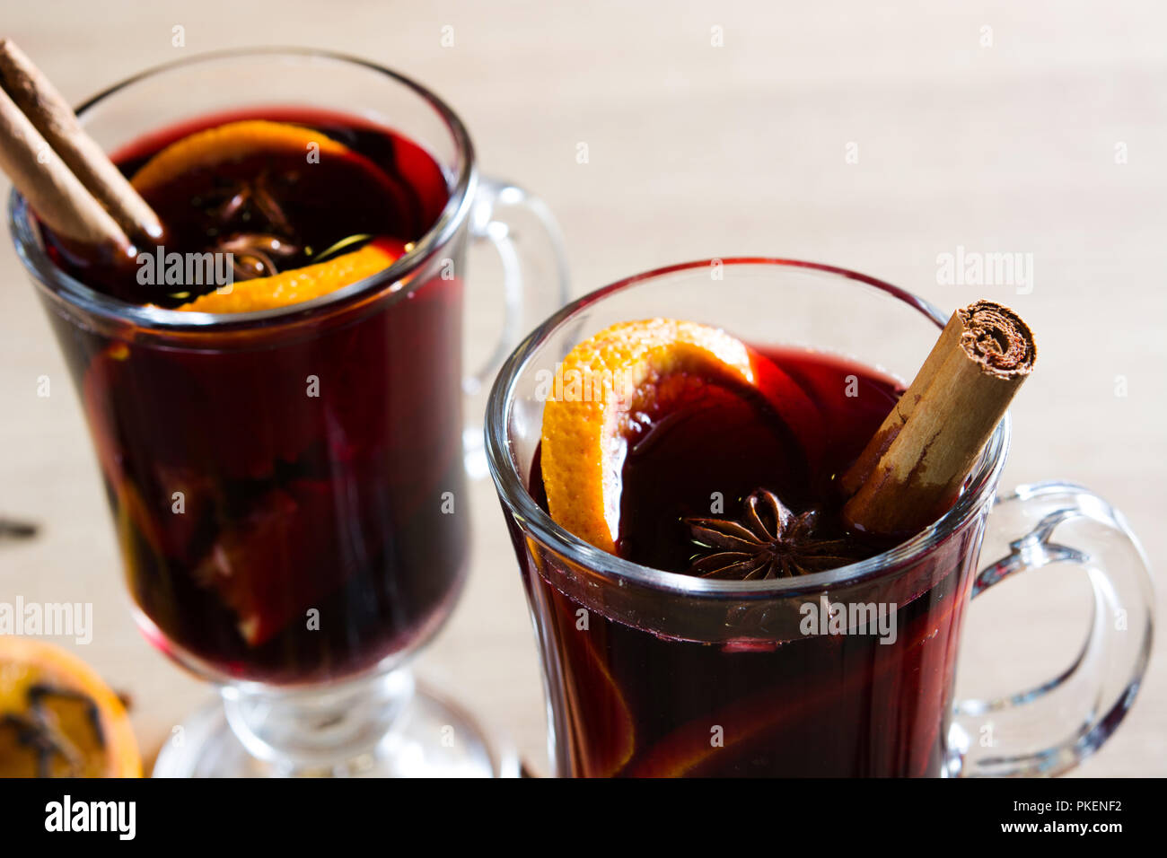 Vin brulé in vetro con spezie e frutta su un tavolo di legno. Foto Stock