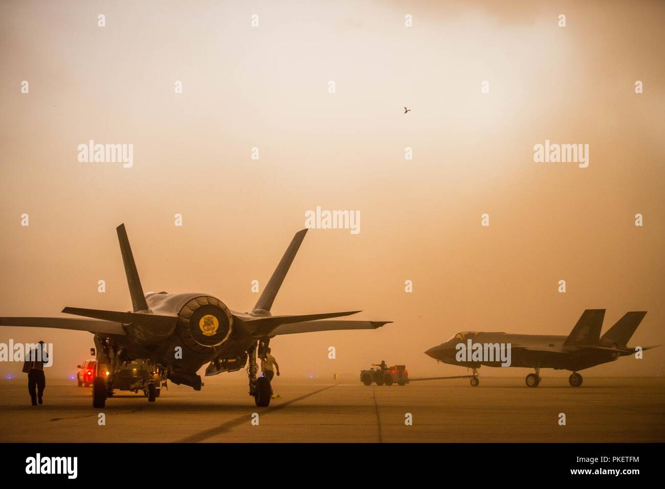 Un U.S. Air Force e la Royal Australian Air Force F-35un fulmine II vengono trainati sulla linea di volo durante il monsone a Luke Air Force Base, Ariz., 30 luglio 2018. Diversi aerei unità di manutenzione hanno sospeso le operazioni di manutenzione di mettersi al riparo dalla polvere. Foto Stock