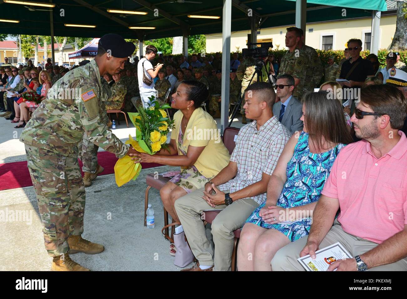 La sig.ra Diane Cloutier, moglie del comandante in arrivo di U.S. Army Africa Il Mag. Gen. Roger L. Cloutier, riceve un bouquet di rose giallo da un U.S. Esercito soldato Africa, durante gli Stati Uniti Esercito Africa-Southern Task Force europea Modifica del comando cerimonia alla Caserma Carlo Ederle a Vicenza, Italia, Agosto 2, 2018. Foto Stock
