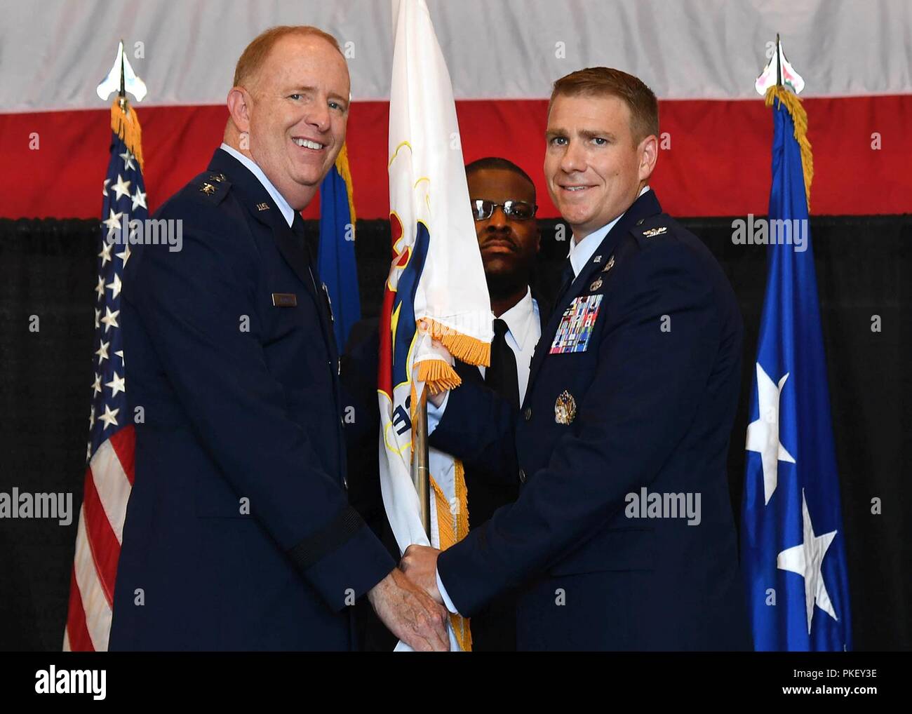 Col. Il Ciad Ellsworth, 66aria gruppo Base commander, accetta il gruppo guidon dal Lt. Gen. Robert McMurry, Jr., Air Force Life Cycle Management Center commander, durante un cambio del comando cerimonia al Hanscom Air Force Base, Massachusetts, 2 agosto come Chief Master Sgt. Henry Hayes, comando installazione chief, guarda a. Come comandante, Ellsworth è responsabile per la protezione, supporto e sostenere più di 5.000 active duty, Riserva e Guardia Nazionale, del personale del Dipartimento della difesa dei civili e dei contraenti, lungo con 130.000 militari in pensione e i coniugi che vivono nel sei-membro del New England e regione Foto Stock