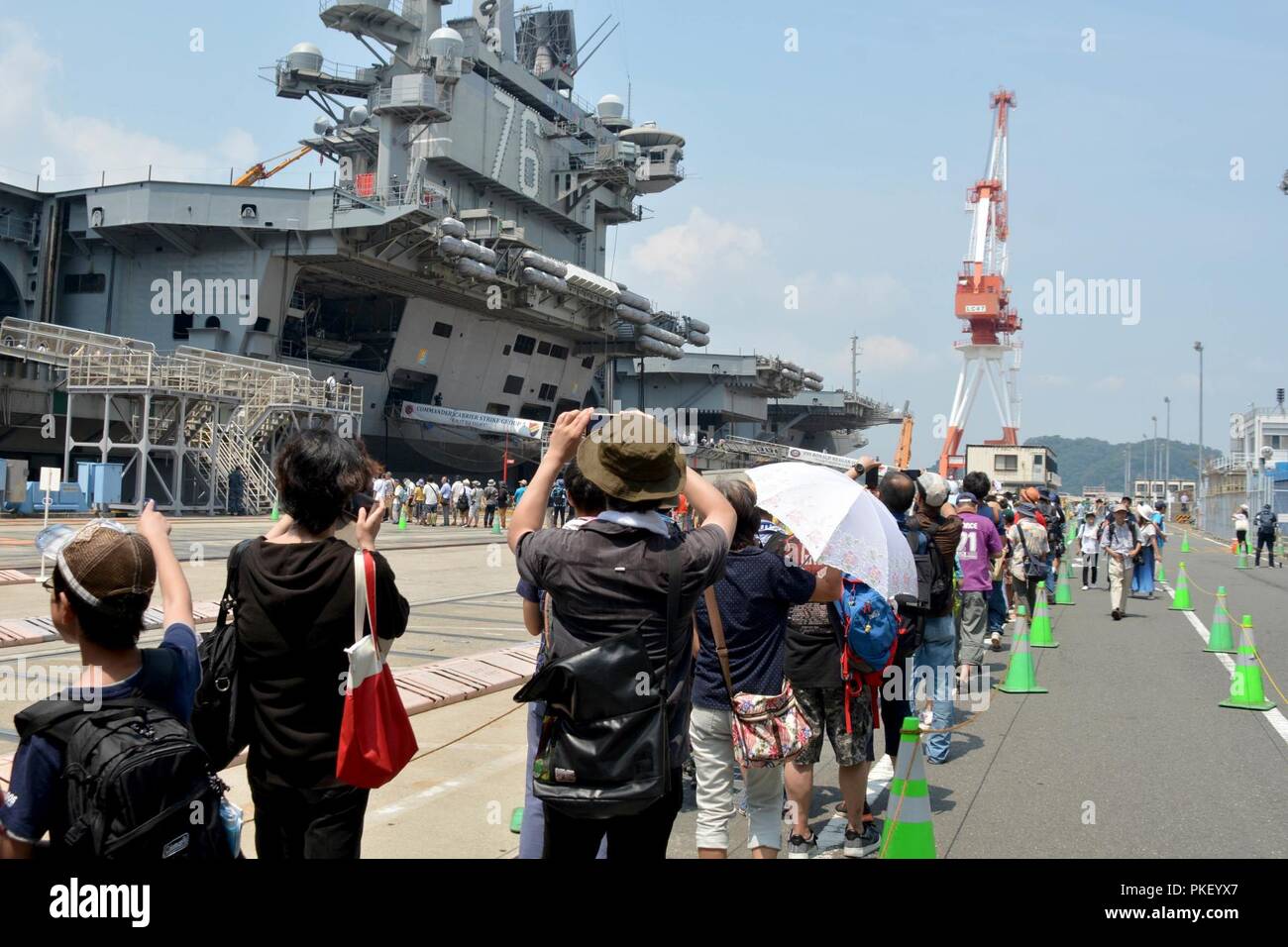 YOKOSUKA, Giappone - gli ospiti di attendere in linea per salire a bordo della U.S. La marina è distribuita portaerei USS Ronald Reagan (CVN 76) durante l'annuale quarantaduesima Yokosuka amicizia Day celebrazione. La base aperta caso evidenzia l amicizia tra Stati Uniti Navy e Giappone. FLEACT Yokosuka fornisce, mantiene e gestisce servizi di base e servizi a sostegno del settimo della flotta di inoltro distribuito le forze navali, 71 comandi di tenant, e 27.000 militari e civili. Foto Stock