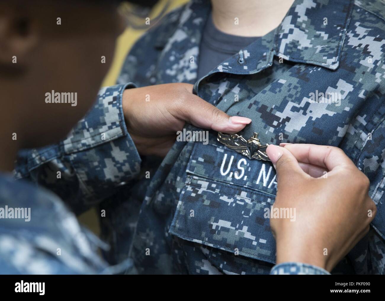 NEWPORT NEWS, Va. (Agosto 3, 2018) della nave marinaio Veteran Melissa Besselman ha, da Lexington, Kentucky, assegnato alla USS Gerald Ford (CVN 78) dipartimento di alimentazione, riceve la sua superficie arruolato Warfare Specialist il perno dalla nave veterano della prima classe Brittany Belcher durante un premi alla cerimonia di quarti in armi area di movimentazione a bordo di Ford. Foto Stock