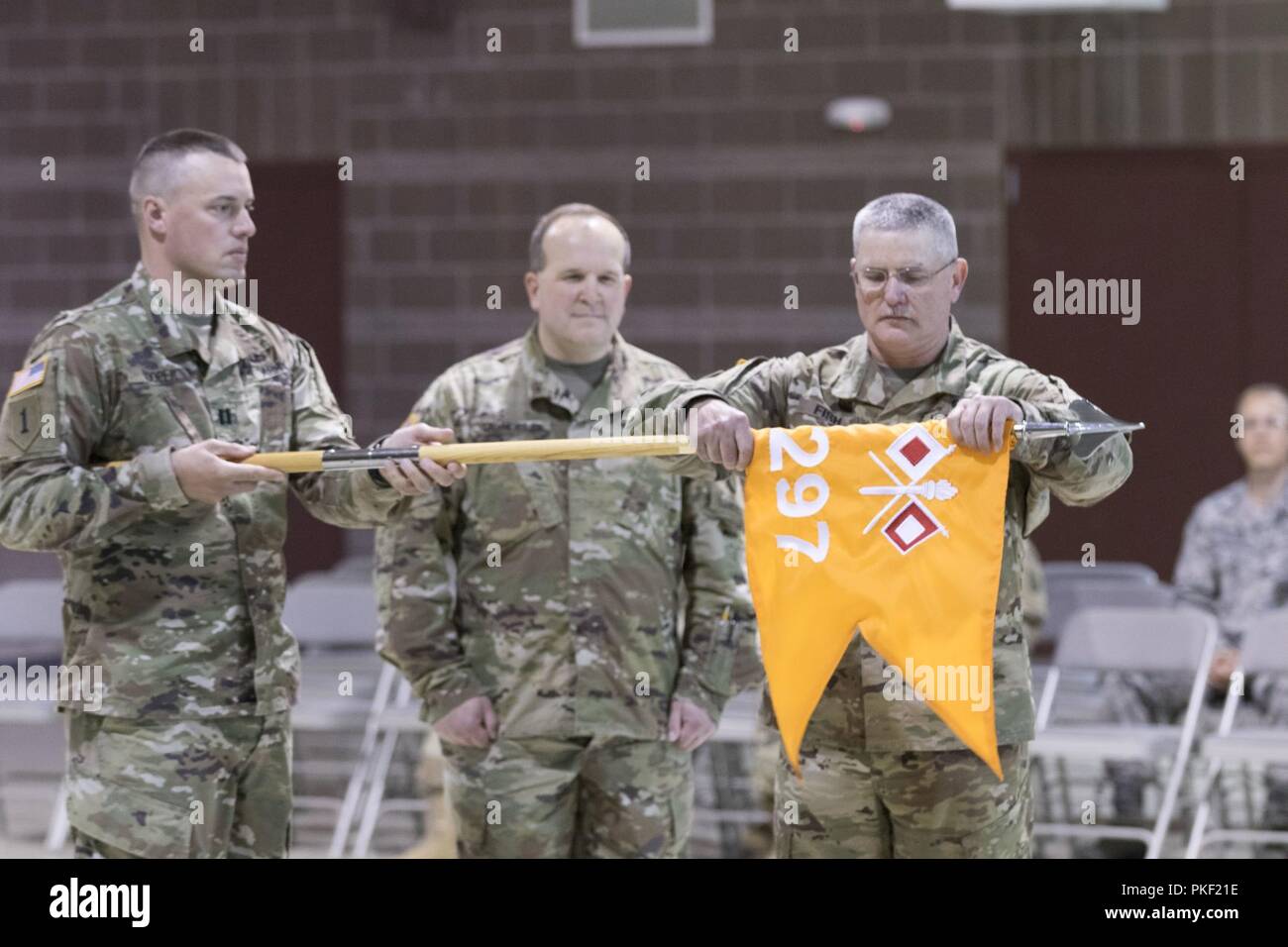 Il cap. Timothy Cooper, 297Signal Company commander, e 1a Sgt. Glenn Pesce, 297SC primo sergente, caso l'unità i colori indicano l'unità di disattivazione il Agosto 5, 2018 in Alaska National Guard Armory su base comune Elmendorf-Richardson. Foto Stock