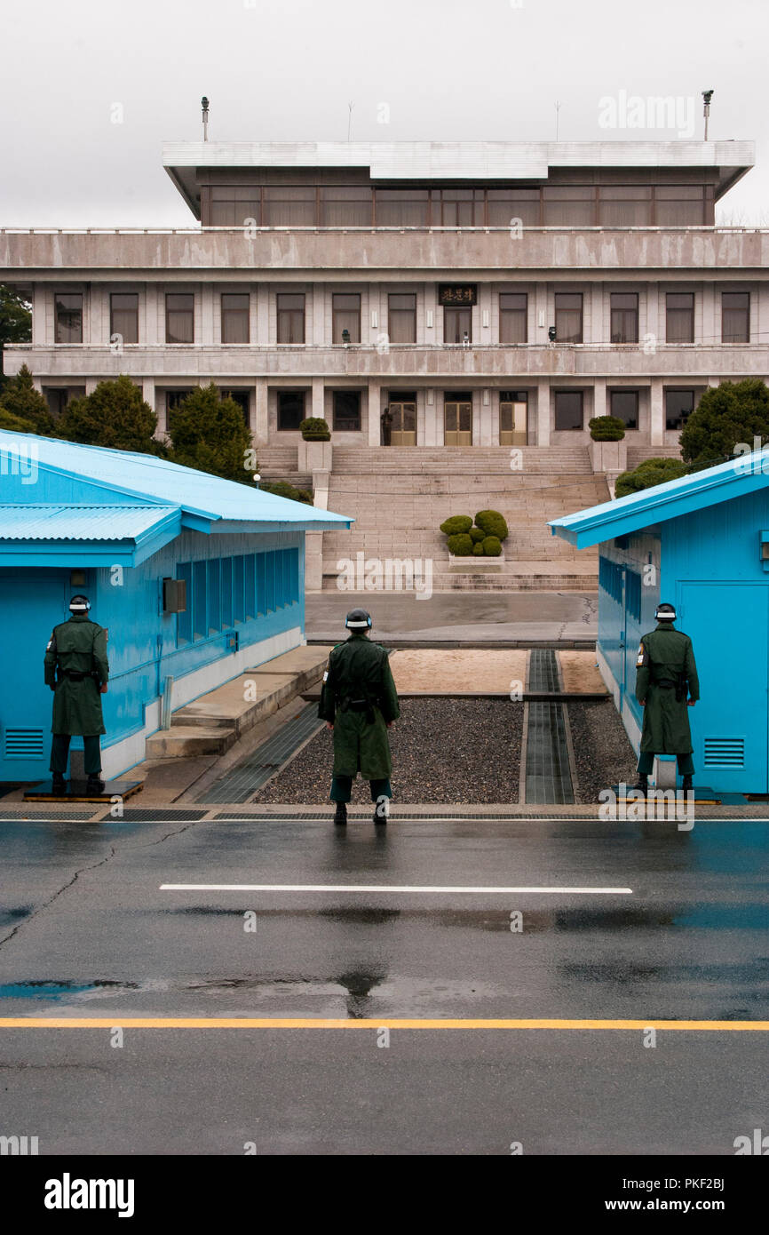 Tre sud coreano soldati che proteggevano la zona demilitarizzata come un nord coreano soldato fa lo stesso. Il personale militare a DMZ sulla penna in coreano Foto Stock