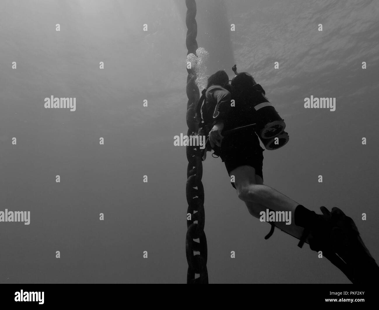 Stati Uniti Navy Hospital Corpsman 1a classe Erich Weber, con costruzione di immersioni subacquee distacco Charlie (CDDC), costruzione subacquea Team 2, ispeziona pesante catena di ormeggio al largo della costa della isola Wake on July 25, 2018. CDDC completato le riparazioni emergenti a Wake Island off-shore di sistema di erogazione del carburante dopo mareggiate scollegato uno della flotta boe di ormeggio. CDDC è il primo arresto del loro sei mesi di schieramento dove stanno realizzando attività di costruzione, ispezione, riparazione e manutenzione di zone costiere oceaniche e strutture a sostegno dell'U.S. 7a flotta. Foto Stock