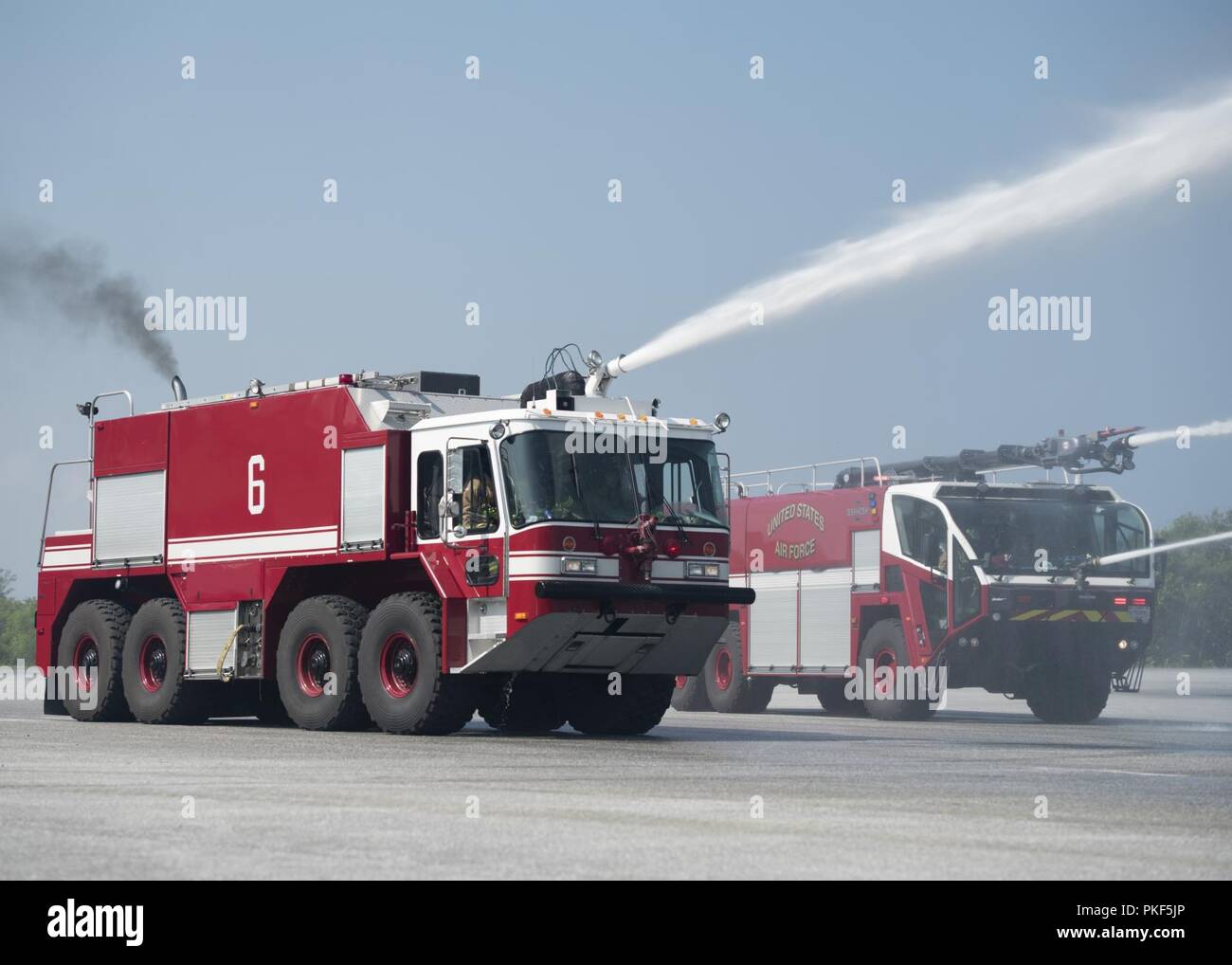 Xviii ingegnere civile Squadron camion fuoco spruzzare acqua sul live-formazione antincendio aerei durante il joint live-formazione antincendio Agosto 7th, 2018 a Kadena Air Base, Giappone. La formazione è la prima sotto una nuova knowledge exchange accordo tra JASDF E GLI STATI UNITI Air Force vigili del fuoco. Foto Stock